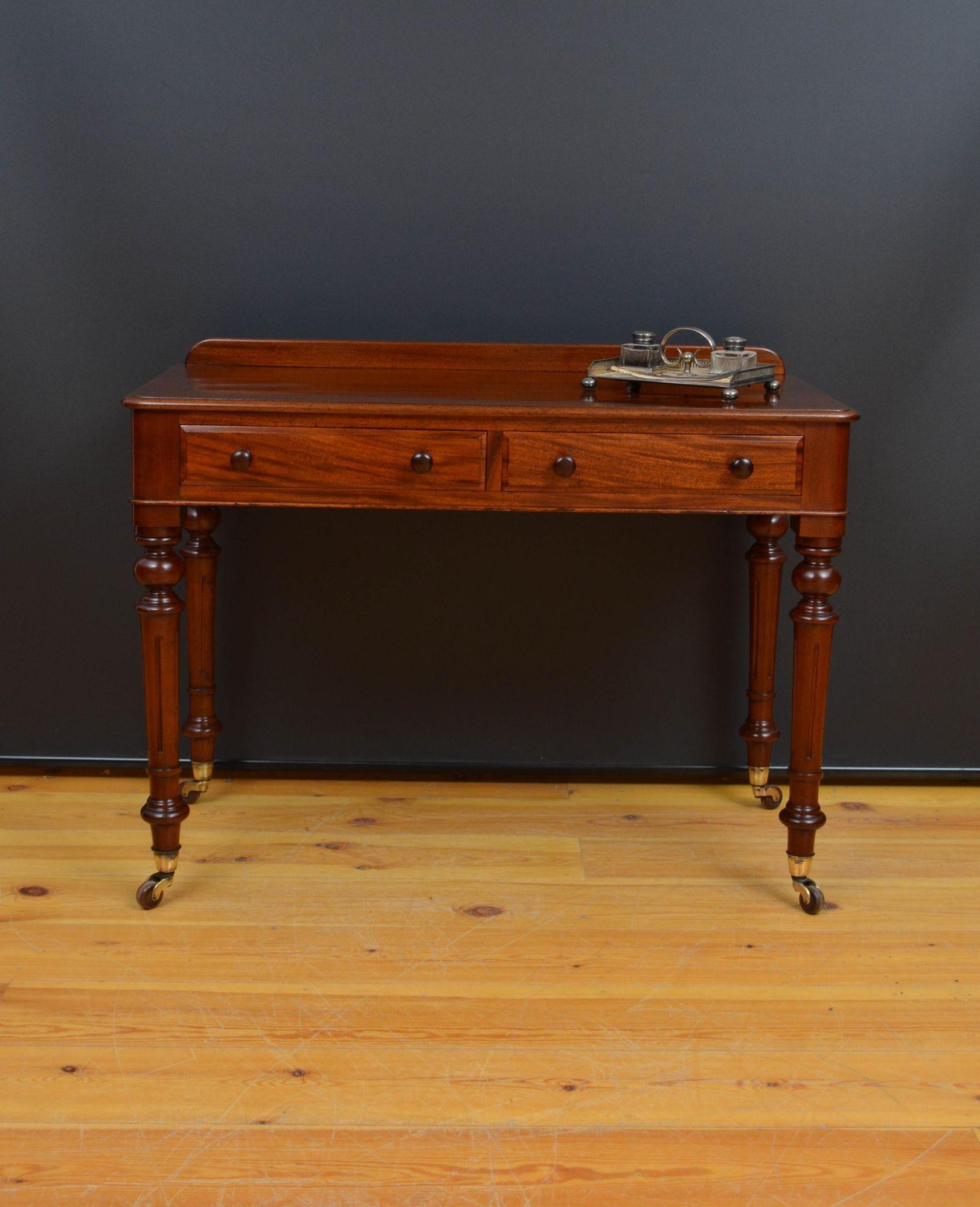 Sn5557 Victorian solid mahogany writing table or dressing table, having shaped upstand to the back, figured mahogany top, panelled sides and two mahogany lined, moulded frieze drawers. Fitted with original turned knobs. All standing on elegant