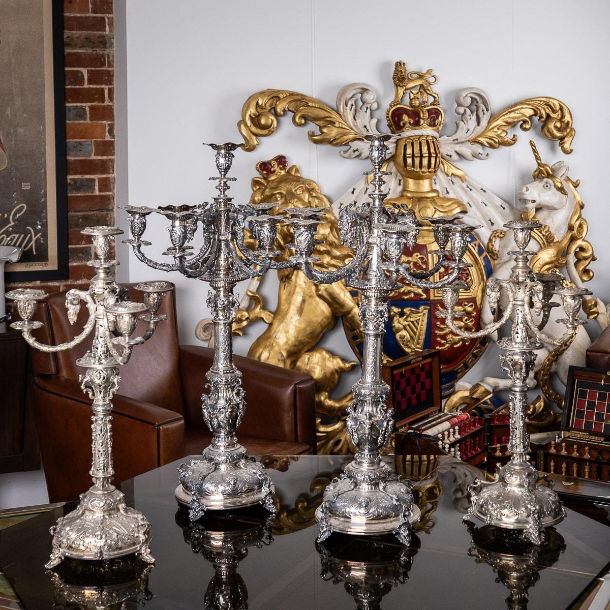 Antique 19th century Victorian exceptional & very unusual set of four solid silver candelabras. Each large seven-light and smaller four-light candelabra set with repousse neoclassical bobéches issuing from ram's head supports, decorated throughout