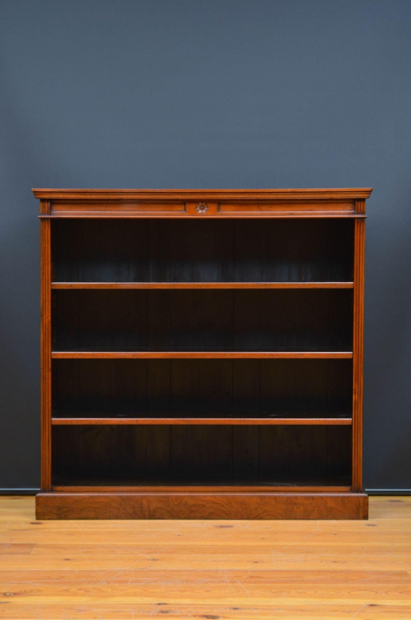 Sn5602 Victorian open bookcase in walnut, having figured walnut top with moulded edge and carved frieze below and three height adjustable shelves, all flanked by fluted pilasters, standing on moulded plinth base. This antique bookcase is in home