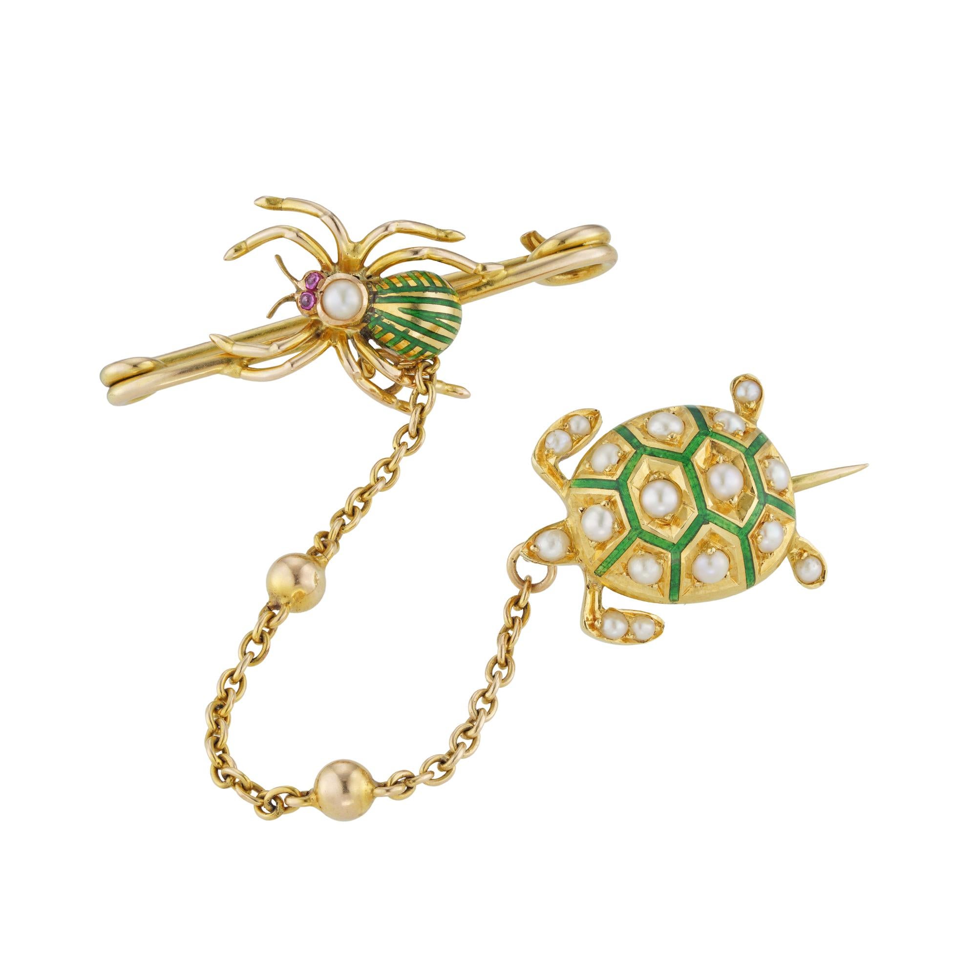 Épingle de fantaisie du début du siècle, composée d'une tortue sertie d'émail vert et de perles, et d'une araignée en émail vert et en perles avec des yeux en rubis taillés en cabochon, le tout en or jaune 18ct et relié par une chaîne ovale, avec