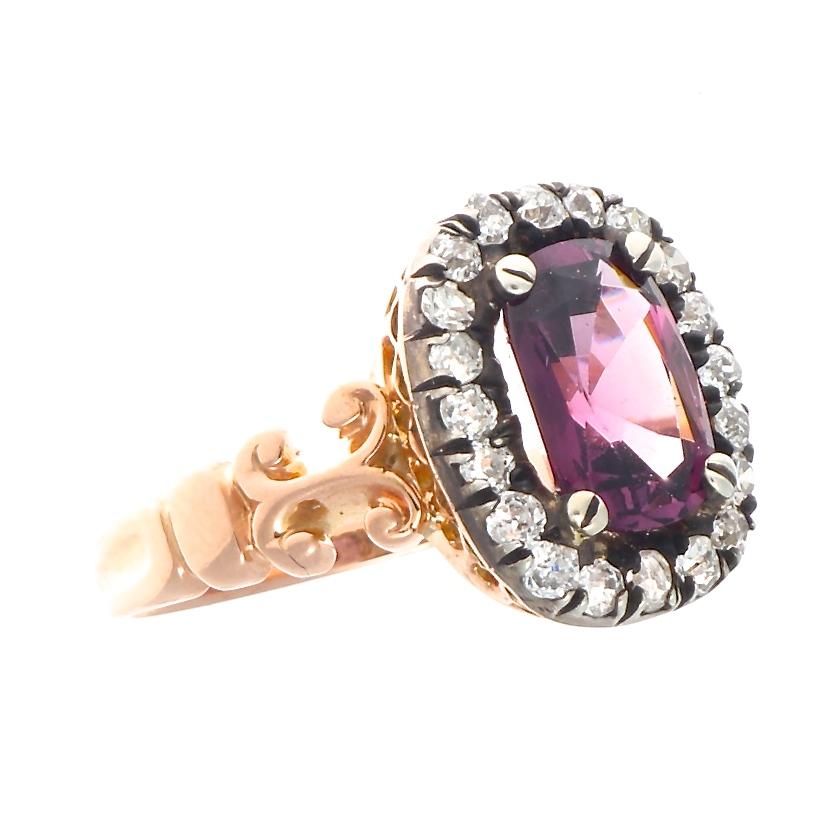 From the romantic era of the Victorian period until today, this ring still signifies true love. Featuring a vivid purplish-pink spinel surrounded by a halo of old cut near colorless diamonds. Crafted in 14k gold.