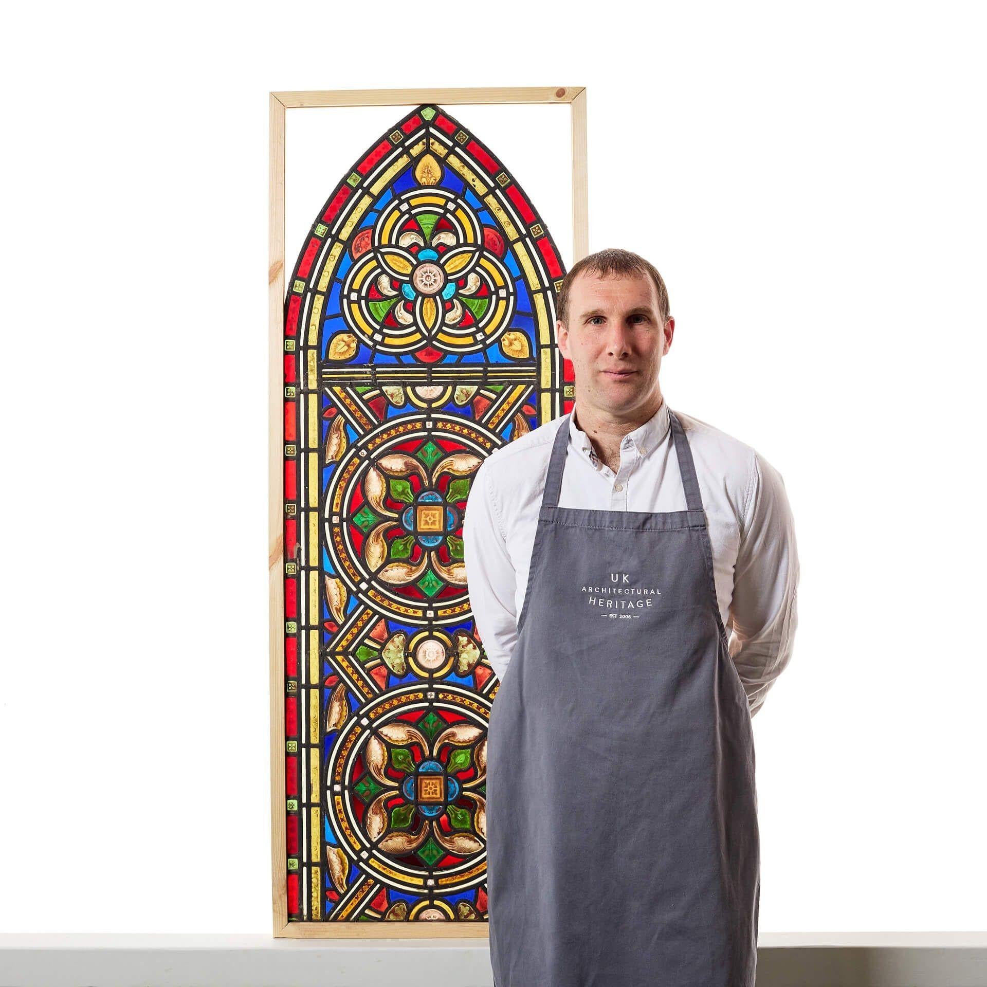 An antique Victorian arched stained glass window showcasing a stylised Tudor rose, originally from a church in northern England.

Three hand painted detailed flowers sit at the heart of this piece. It incorporates both ecclesiastical and medieval
