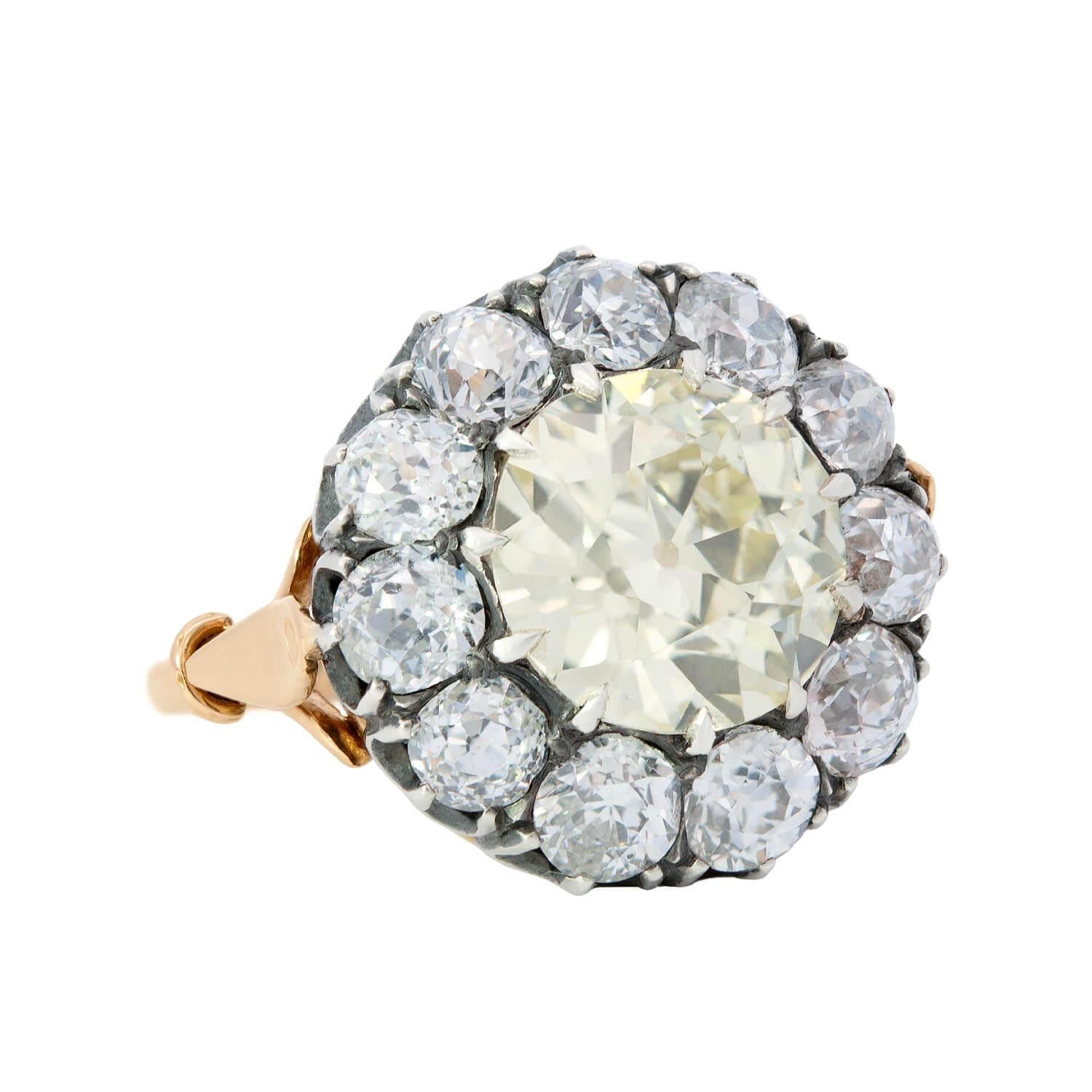 An exquisite diamond cluster ring from the Victorian era (ca1880)! This elegant ring is crafted in sterling silver and 18k gold and has a dazzling diamond design. Resting at the center is a gorgeous 2.68ct old Mine Cut diamond, which has estimated