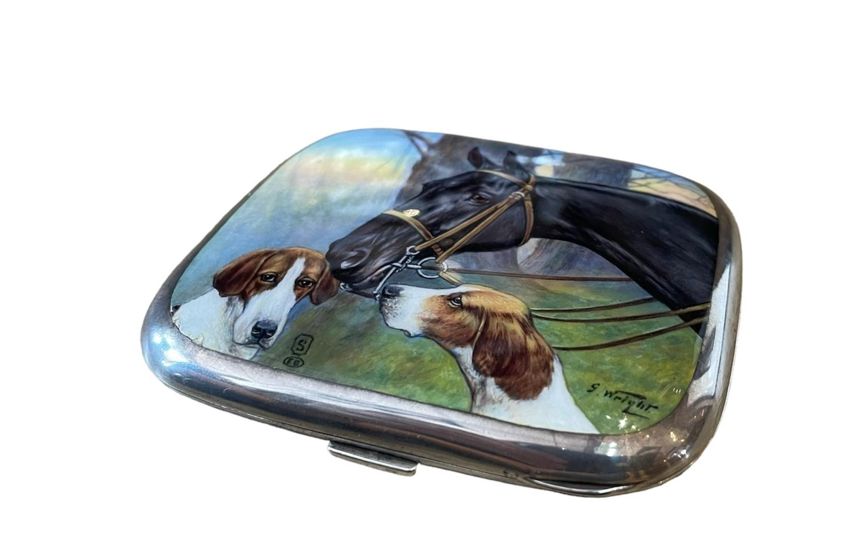 Se trata de una pitillera europea de plata de ley y esmalte. Representa una caja rectangular con bisagras de plata de ley con una pintura esmaltada de un caballo y dos perros de caza de George Wright. An He fue un renombrado artista equino inglés de