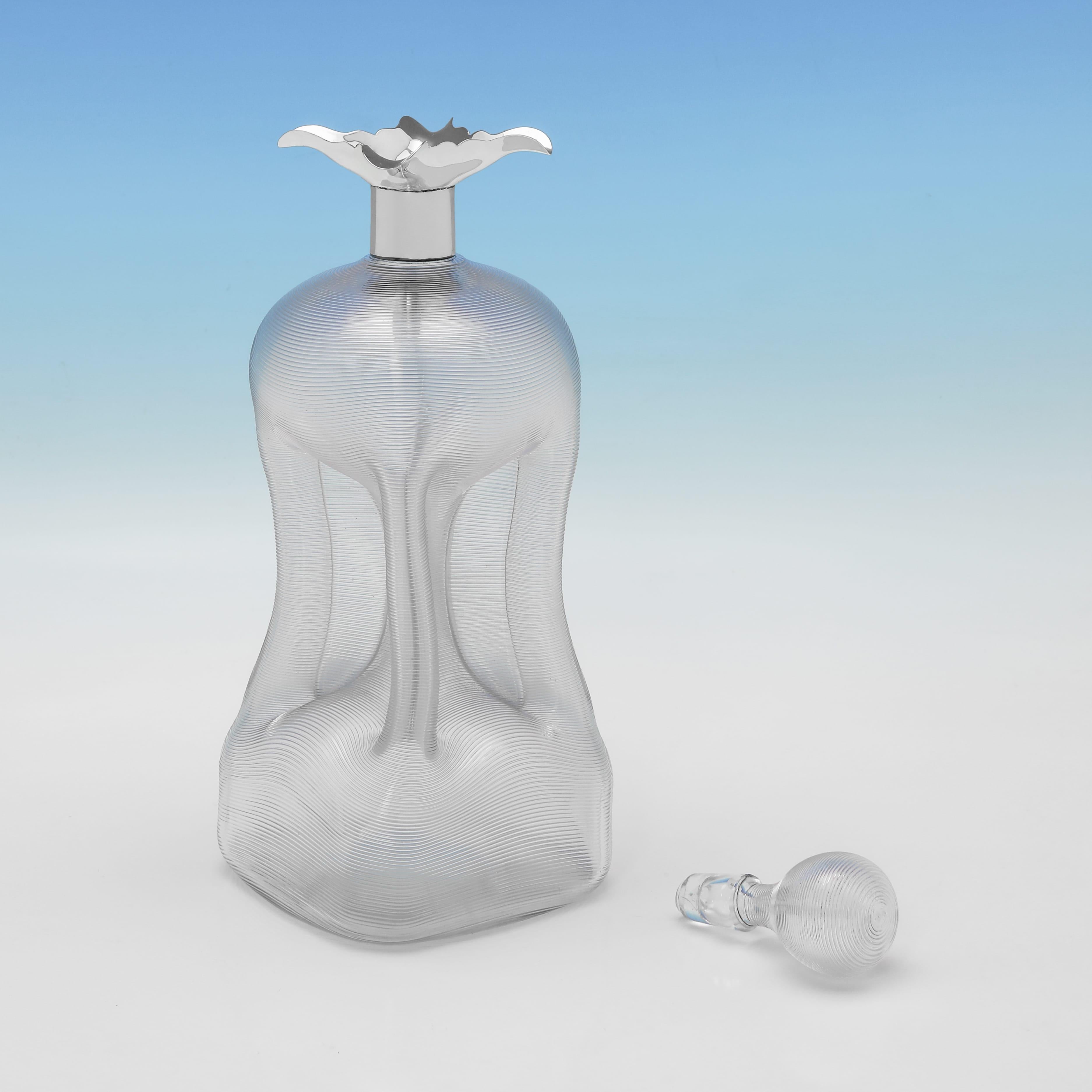 Poinçonnée à Londres en 1893 par Mappin & Webb, cette élégante carafe victorienne en argent sterling ancien présente un corps et un bouchon en verre, tous deux striés, ainsi qu'une monture en argent avec quatre lèvres pour le versement. La carafe