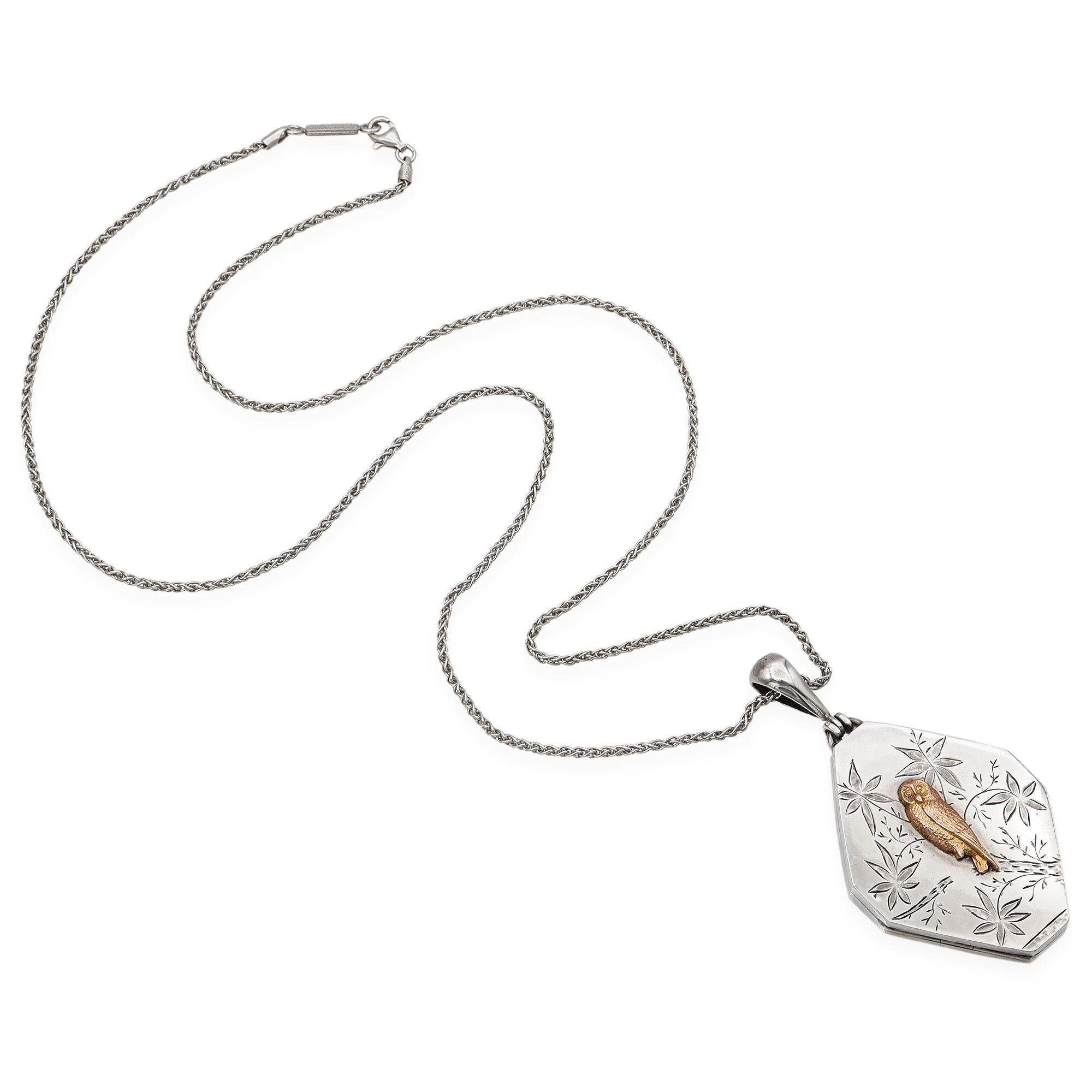 Questo elegante medaglione è realizzato in argento sterling e oro e presenta intricate incisioni floreali che circondano un gufo finemente dettagliato, in oro vermeil dai toni caldi. Il ciondolo ottagonale è appeso a una classica catenina