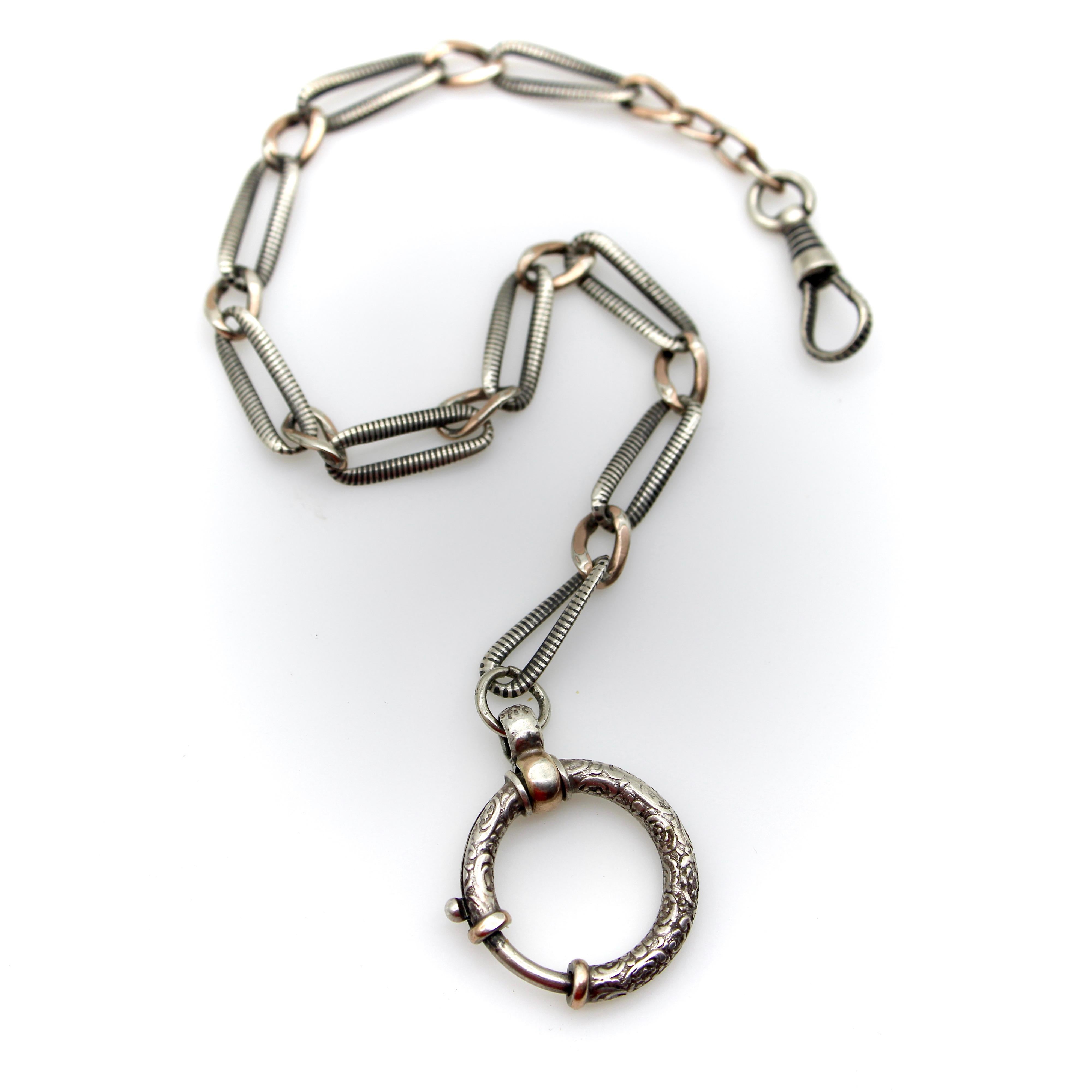 Questa catena da orologio vittoriana in argento sterling ha caratteristiche uniche che la rendono una catena speciale. È composto da maglie allungate ritorte alternate a maglie ovali più piccole. Le maglie allungate hanno un bellissimo niello che