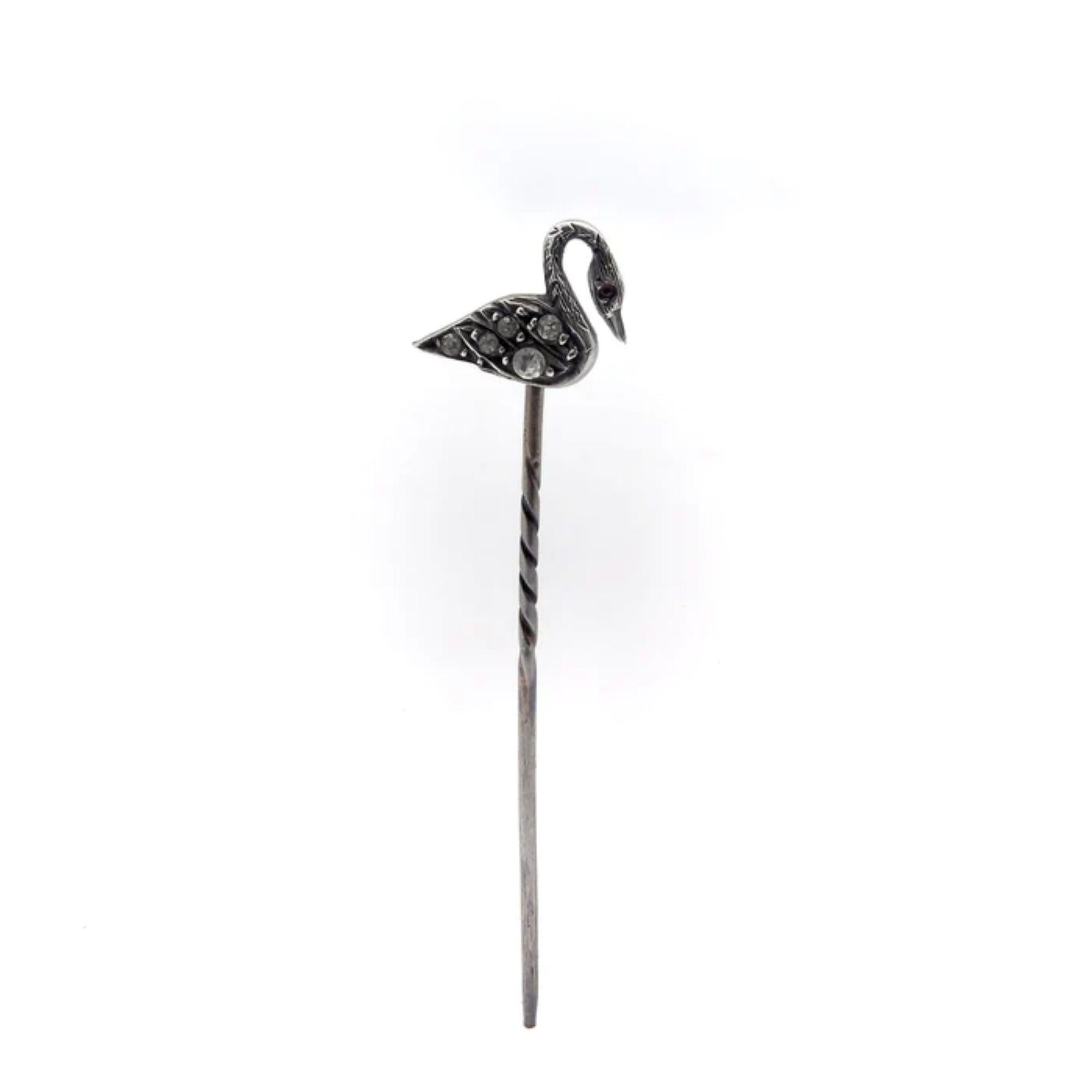 The swan on this Victorian-era stickpin is adorned with five hand-cut high table paste stones in its wings and a ruby cabochon for its eye. The sterling silver is well-oxidized making for a beautiful patina that offsets the paste stones and creates