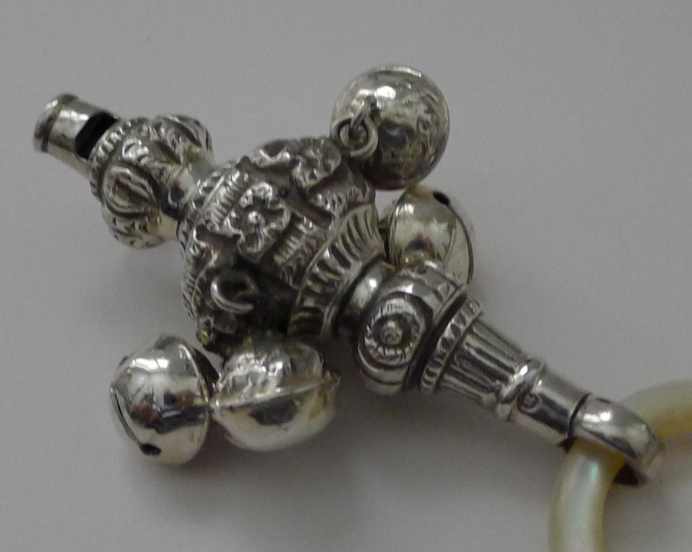 A charming example of a sterling silver baby rattle complete with working whistle and an iridescent Mother of Pearl teething ring.

The rattle has four bells and everything in great condition, these make the most wonderful heirloom gifts for the new