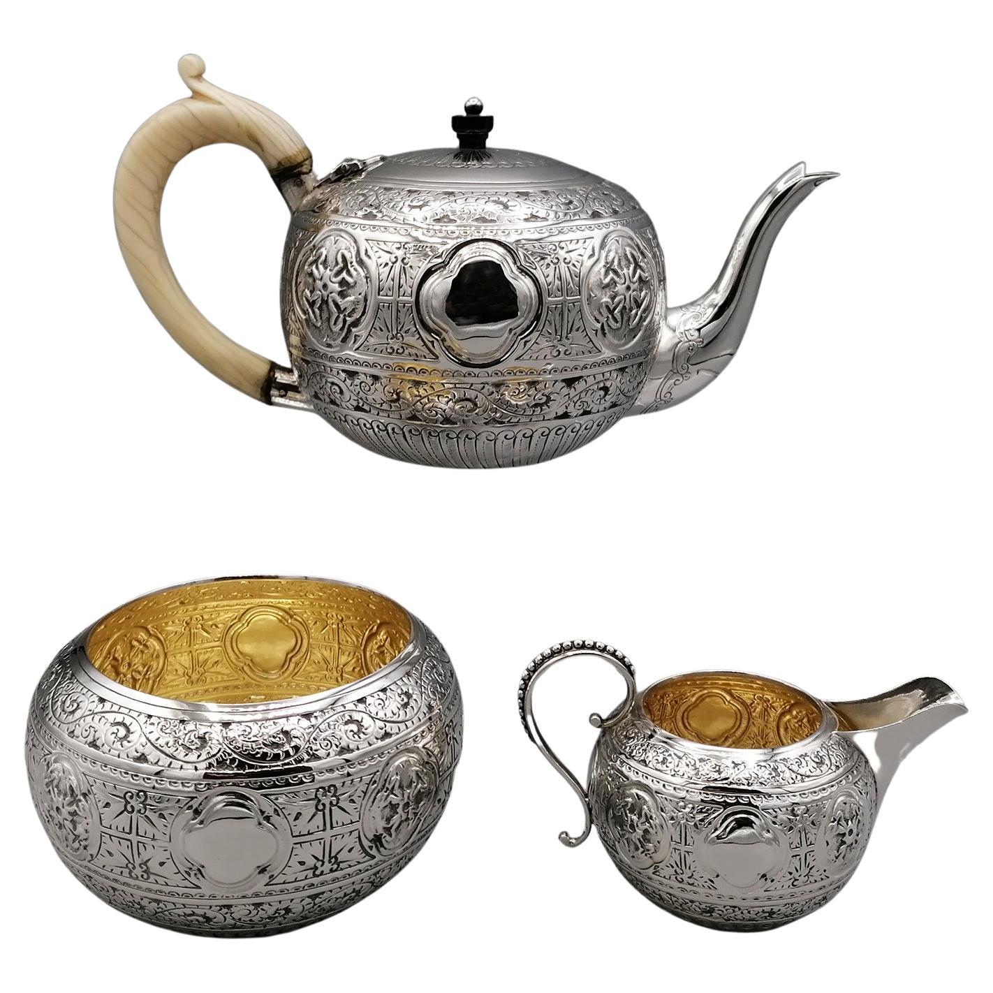 Fine sterling bachelor sterling silver tea set.
Finely chiselled and engraved on the entire outside with scroll and torchon motifs. 
The inside of the milk jug and sugar bowl is finished with a satin gold finish.
The teapot has an ivory