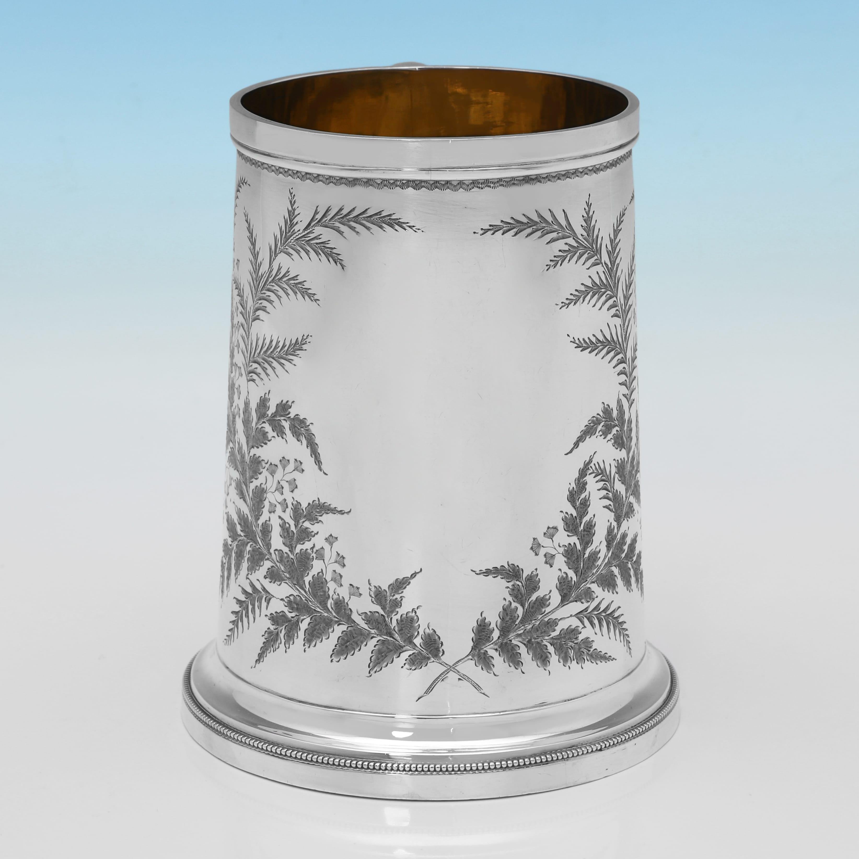 Poinçonnée à Londres en 1890 par George Maudley Jackson, cette attrayante tasse victorienne en argent sterling ancien présente un côté droit, une superbe décoration gravée sur le corps, une anse, un intérieur doré et une base évasée. La tasse mesure