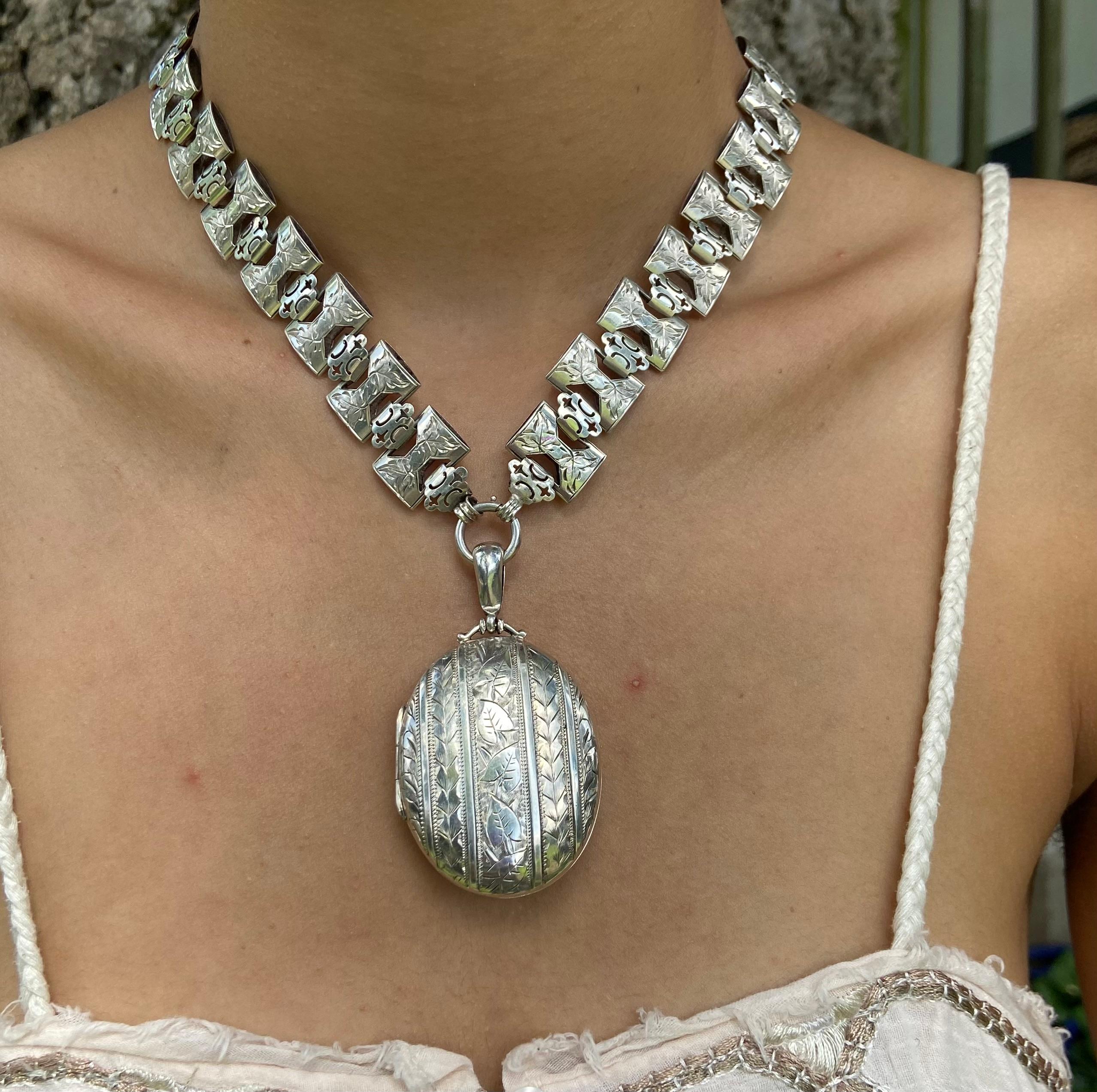 Una collana d'argento con catenina e medaglione che presenta la splendida incisione dell'epoca vittoriana ed è intrisa di simbolismo di unità e connessione. Il medaglione è intatto e ha due cornici ovali interne per le tue fotografie. Si chiude con