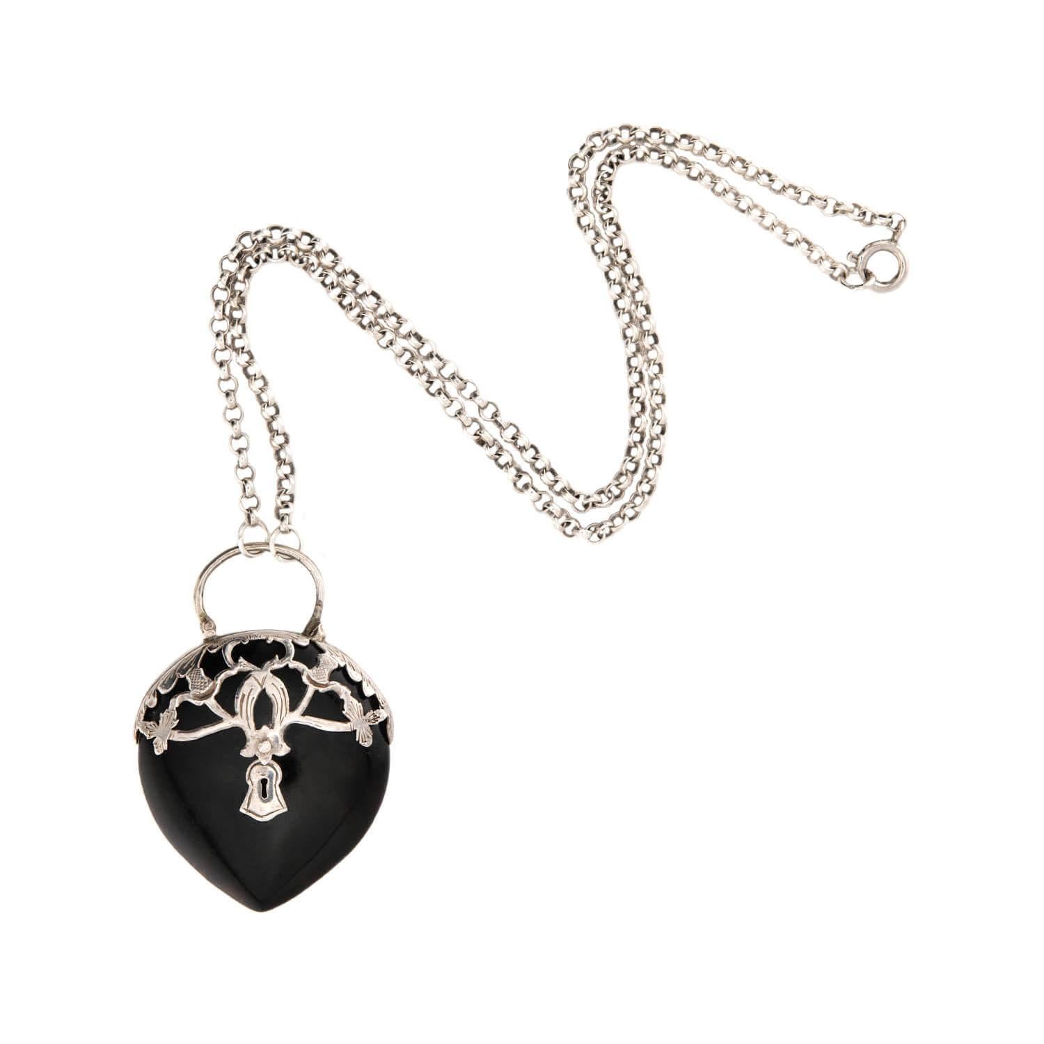Diese ungewöhnliche Anhänger-Halskette aus der viktorianischen Ära (ca. 1880er Jahre) ist ein wunderbares Beispiel für Schmuck aus geschnitztem Horn! Das Stück beginnt mit einer schlichten Sterlingsilber-Rollokette, die mit einem Federringverschluss