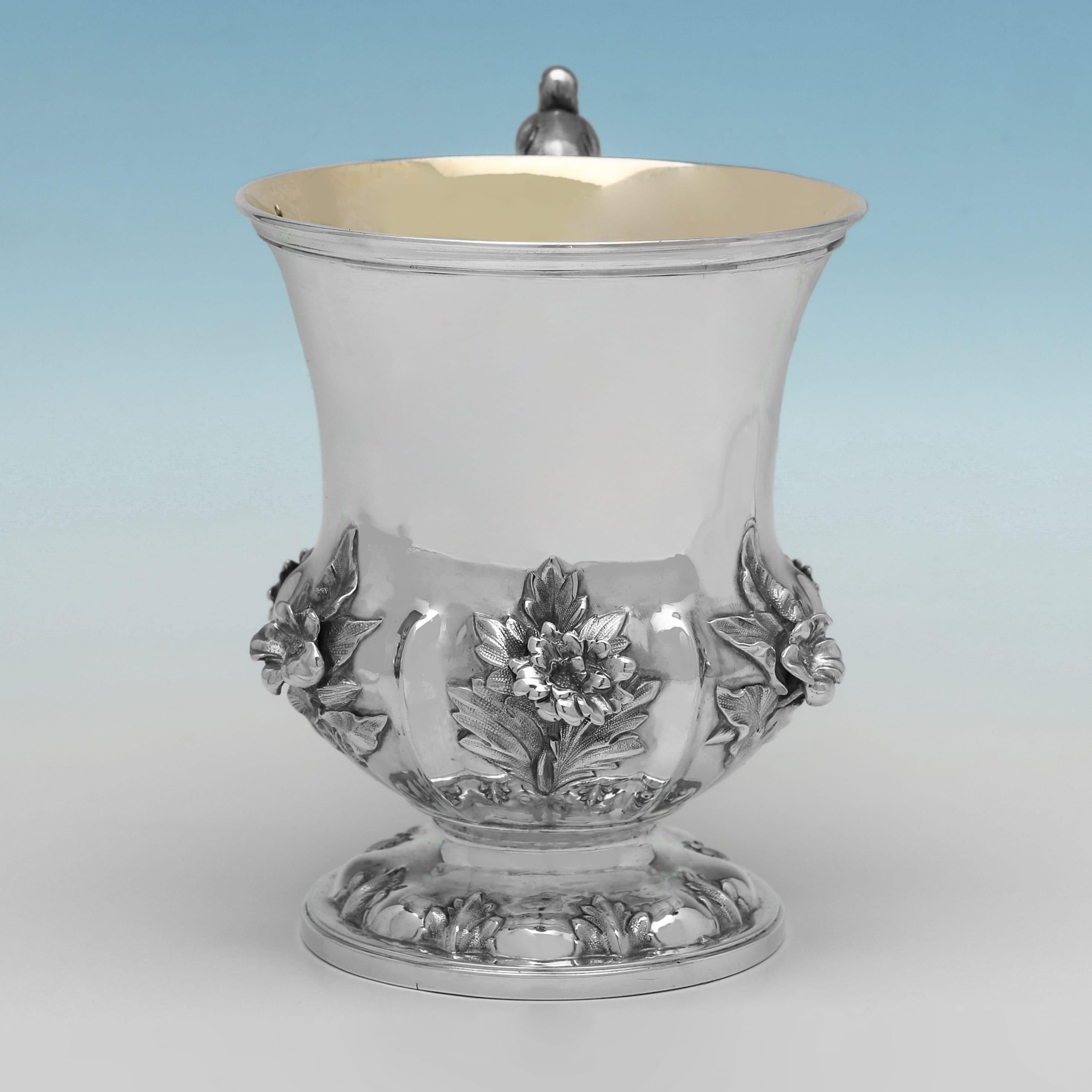 Poinçonnée à Londres en 1842 par Edward, Edward Junior, John & William Barnards, cette charmante tasse de baptême victorienne en argent sterling ancien présente une décoration florale ornée sur le corps, un intérieur doré et une poignée en volute
