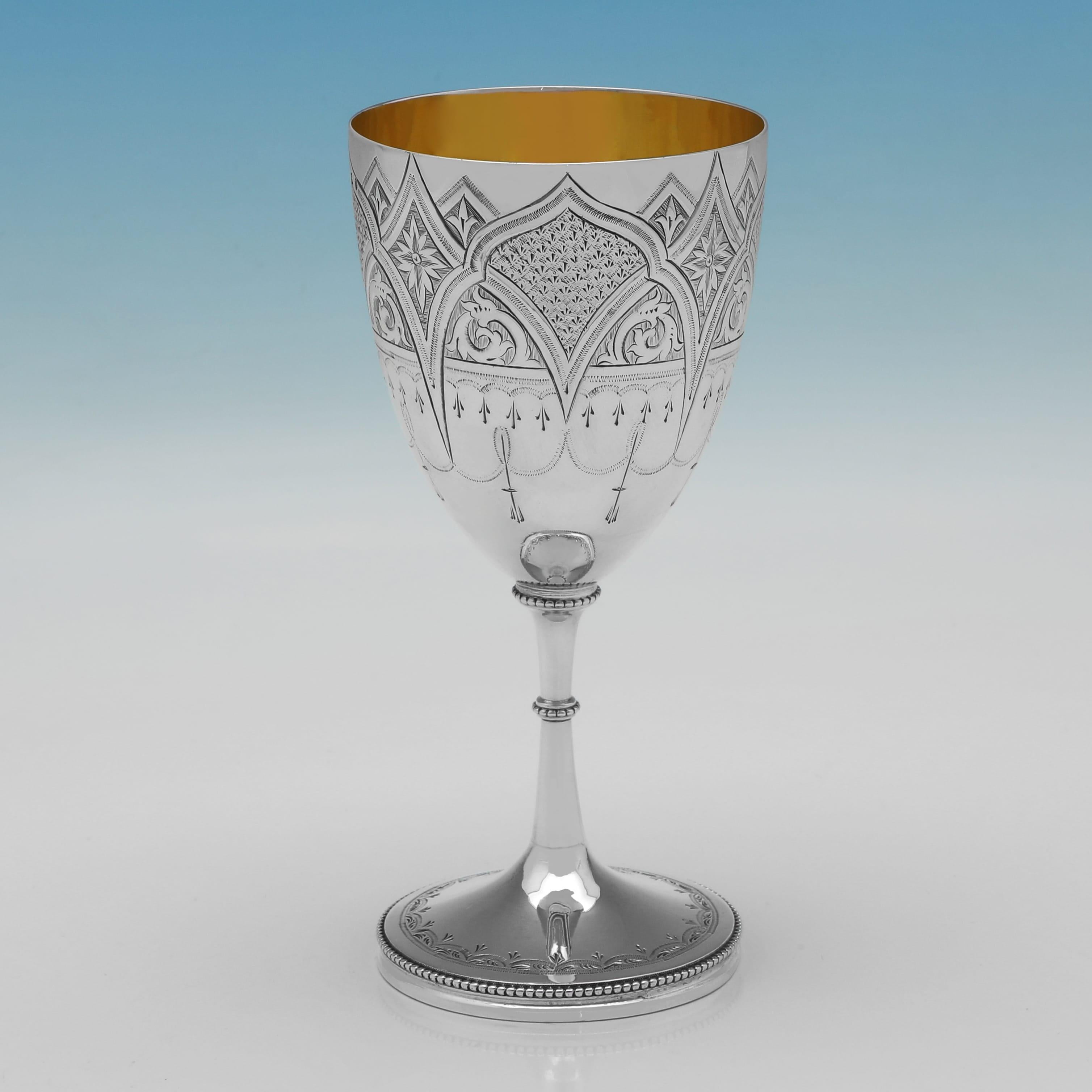 Hallmarked in Birmingham in 1869 by George Unite, this attractive, antique, Victorian, sterling silver goblet features detailed engraved decoration to the body, a gilt interior, and stands on a circular pedestal foot with a bead border and matching