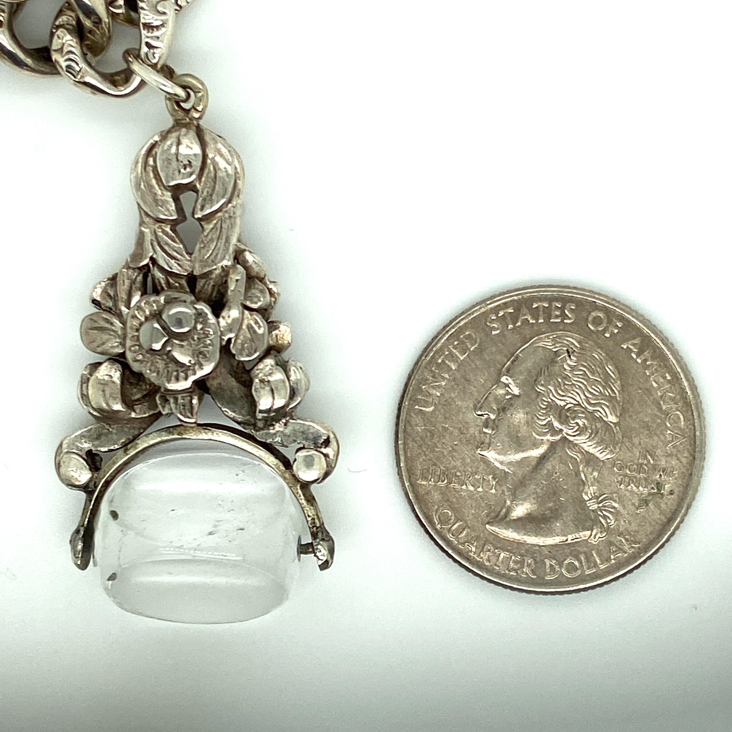 One sterling silver Victorian gate bracelet features engrave links and a three-sided rock crystal quartz watch fob soldered to the bracelet.  The bracelet measures eight inches long. 