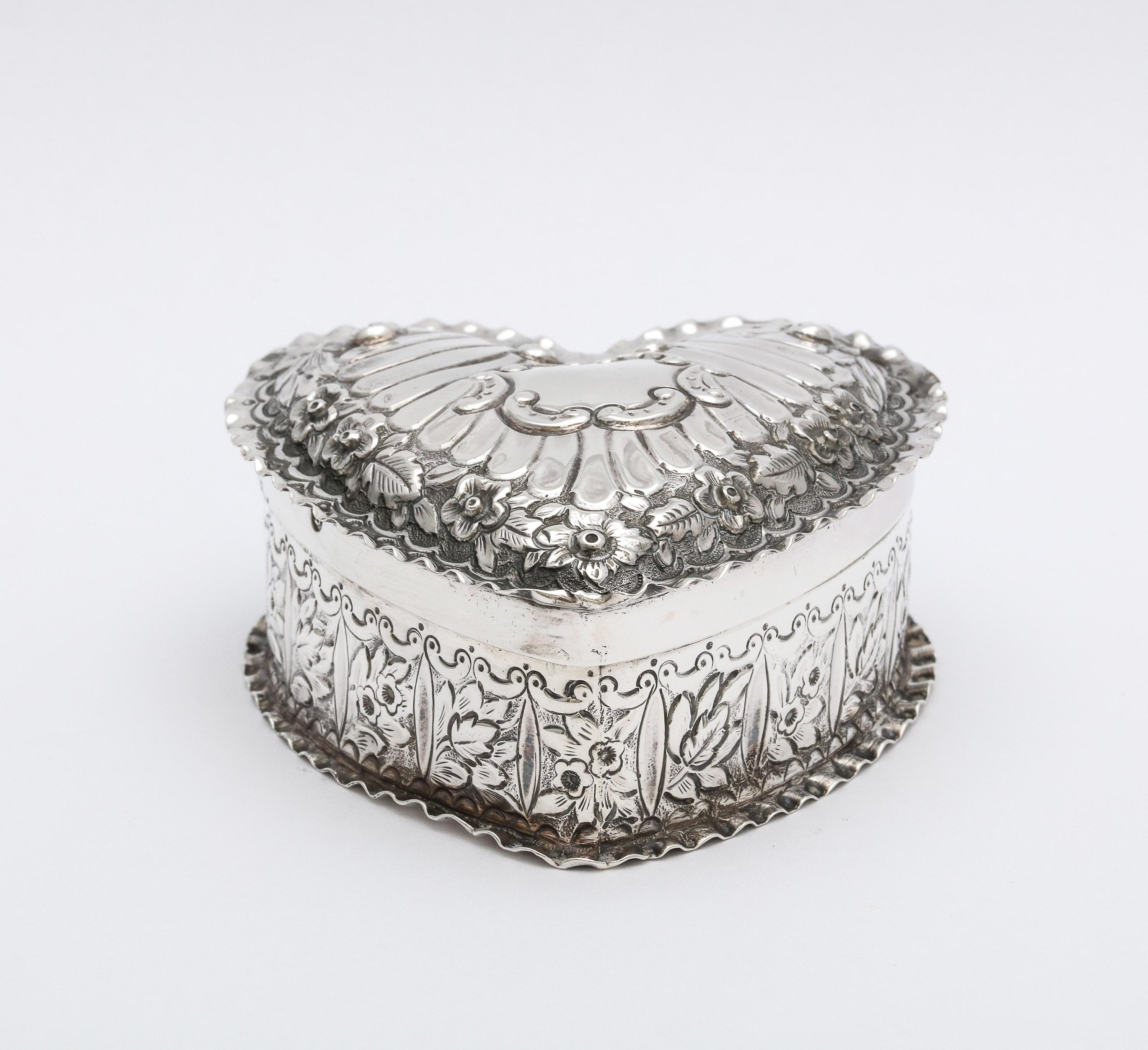 Victorian, sterling silver heart-form trinkets box with hinged lid, Birmingham, England, 1890, T. Hayes - maker. Gilded interior. Measures 2 3/4 inches deep x 2 3/4 inches wide (at widest point) x 1 1/4 inches high. Weighs 1.940 troy ounces. Vacant