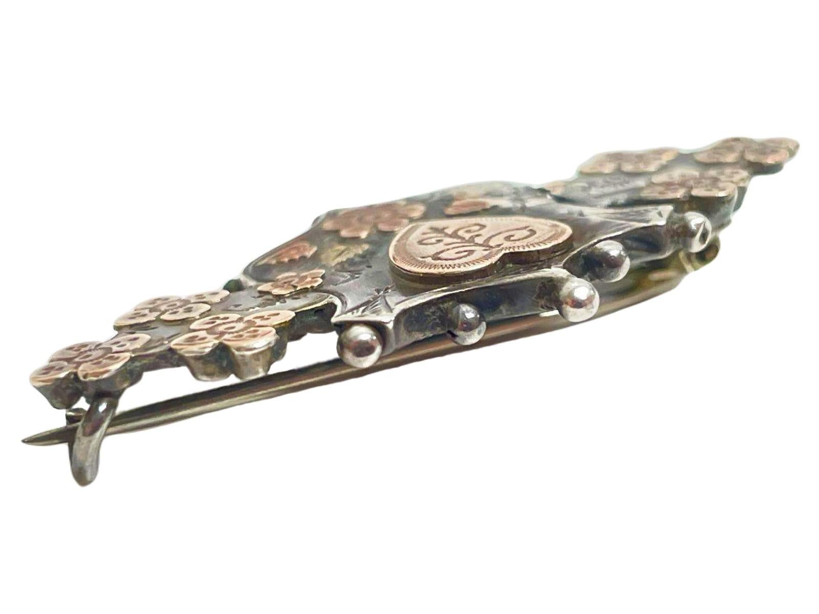 This exquisite, one-of-a-kind antique love token brooch is a stunning example of 19th-century romantic jewelry. This is a wonderful piece dating to 1894, crafted from sterling silver overlaid with yellow gold and rose gold. It features unique
