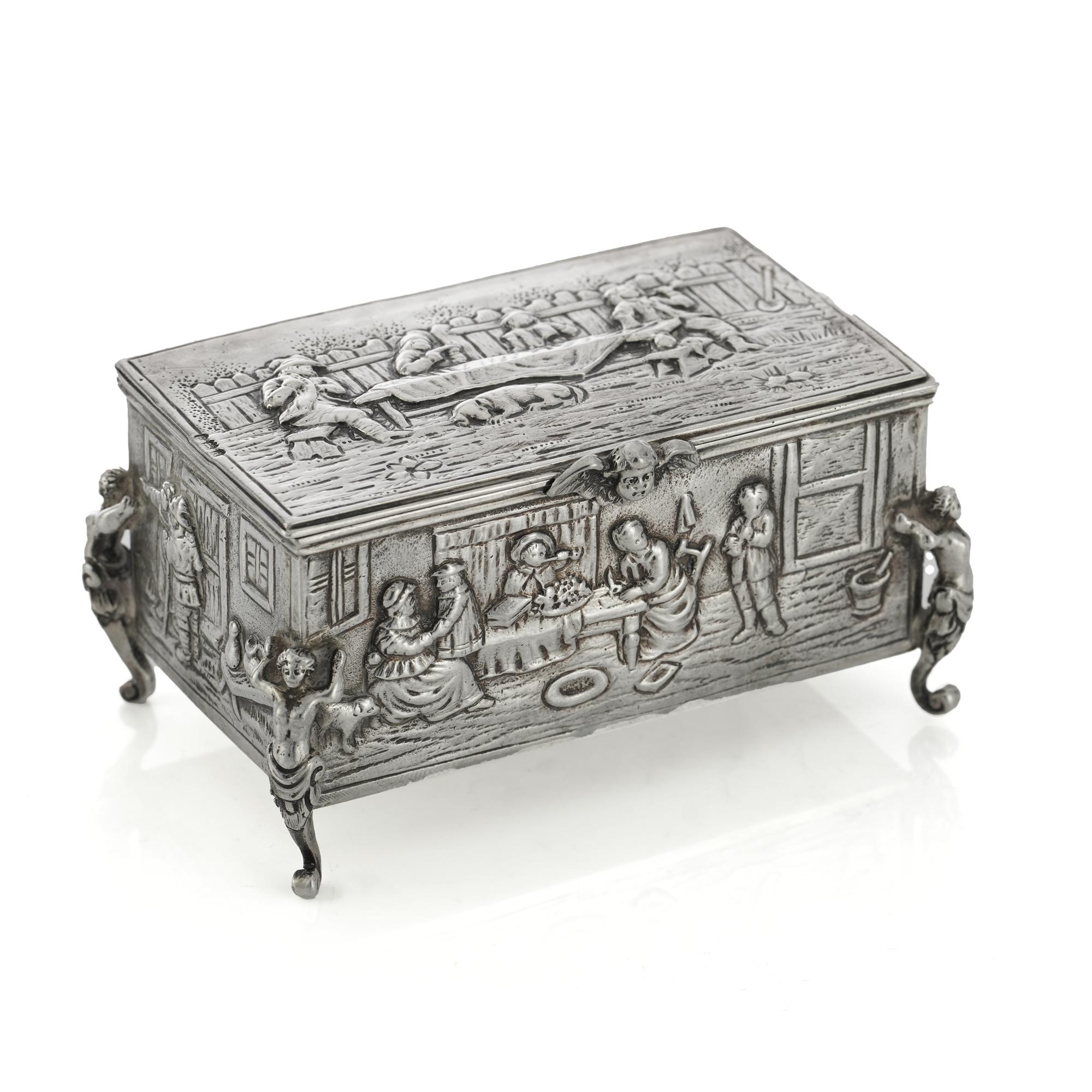Antique late Victorian Sterling silver jewellery box with daily life scenes and characters.
Hallmarked with London import marks, 1896 and Hanau silver marks.

Approx. Dimensions -
Length x width x height: 9 x 5.3 x 4.6 cm
Weight: 125 grams in
