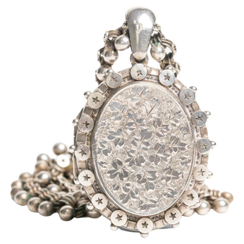 Antique Victorian sterling silver locket necklace dated 1880. This gorgeous silver locket is fully hallmarked for Birmingham and it was made by very well-known Birmingham jewellers: T & J Bragg Ltd. The front of the piece is decorated with a