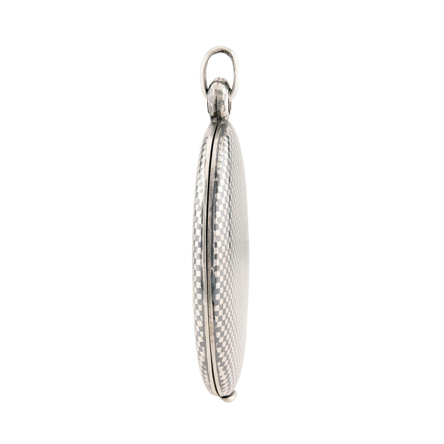 Un fabuleux médaillon en argent de l'époque victorienne (vers les années 1880) ! Ce magnifique médaillon ovale en argent sterling est orné d'un motif unique en damier niellé au recto et au verso. Lorsqu'il est ouvert, le médaillon présente deux