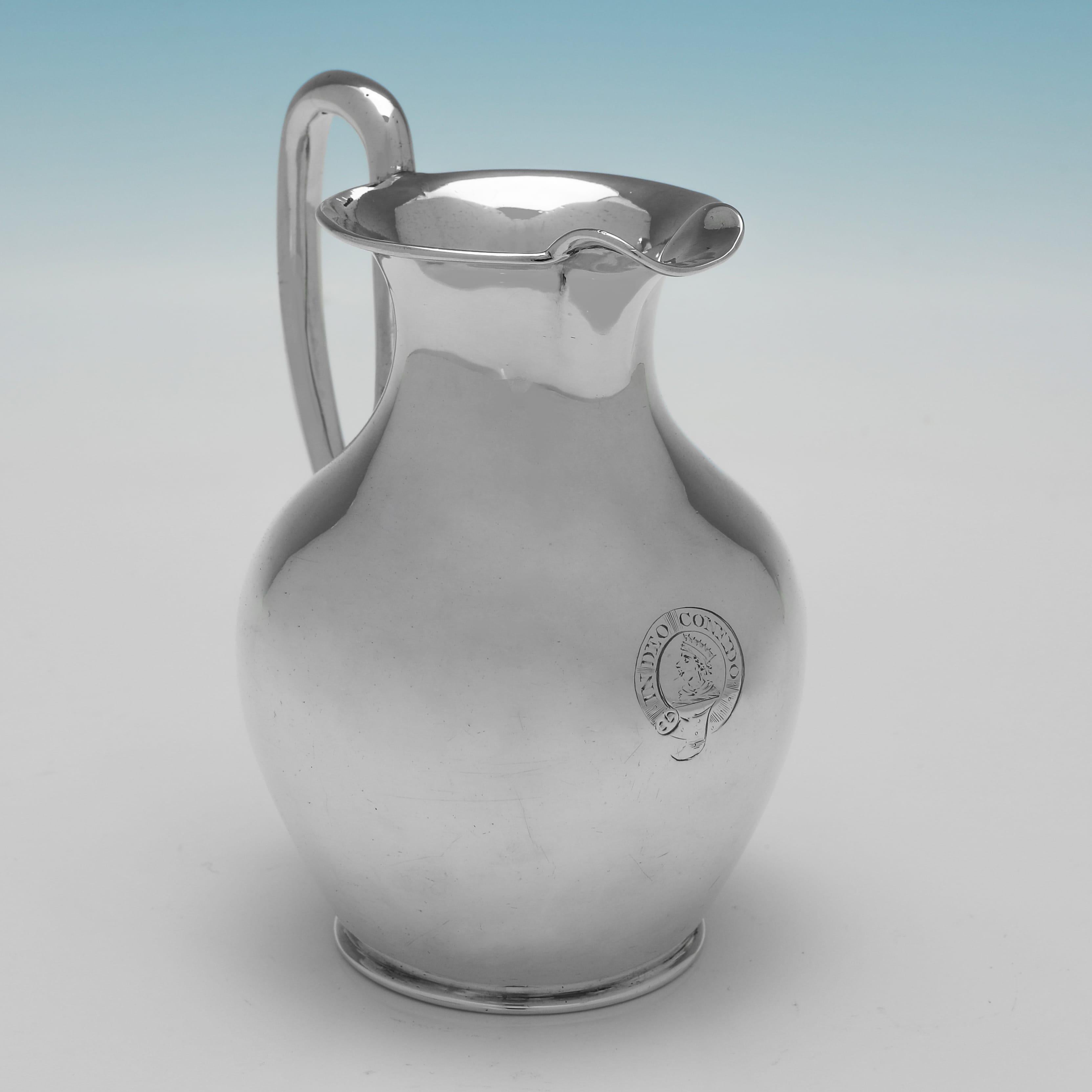 Hallmarked in London in 1847 by Joseph Angell I & Joseph Angell II, this stylish, Victorian, Antique Sterling Silver Cream Jug, is modelled to resemble an Oenochoe, a key form used in Ancient Greek pottery, and is engraved to the front with a crest
