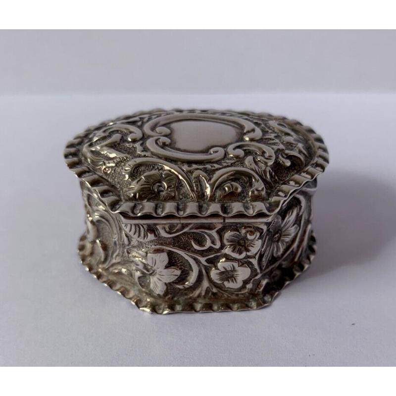 In good vintage condition, this pill box is oval shape in design with a plain body, a hinged lid decorated with flowers, leaves and swirls. It rests on a flat base.  The interior of this box has been nicely gilded.  It would make an interesting