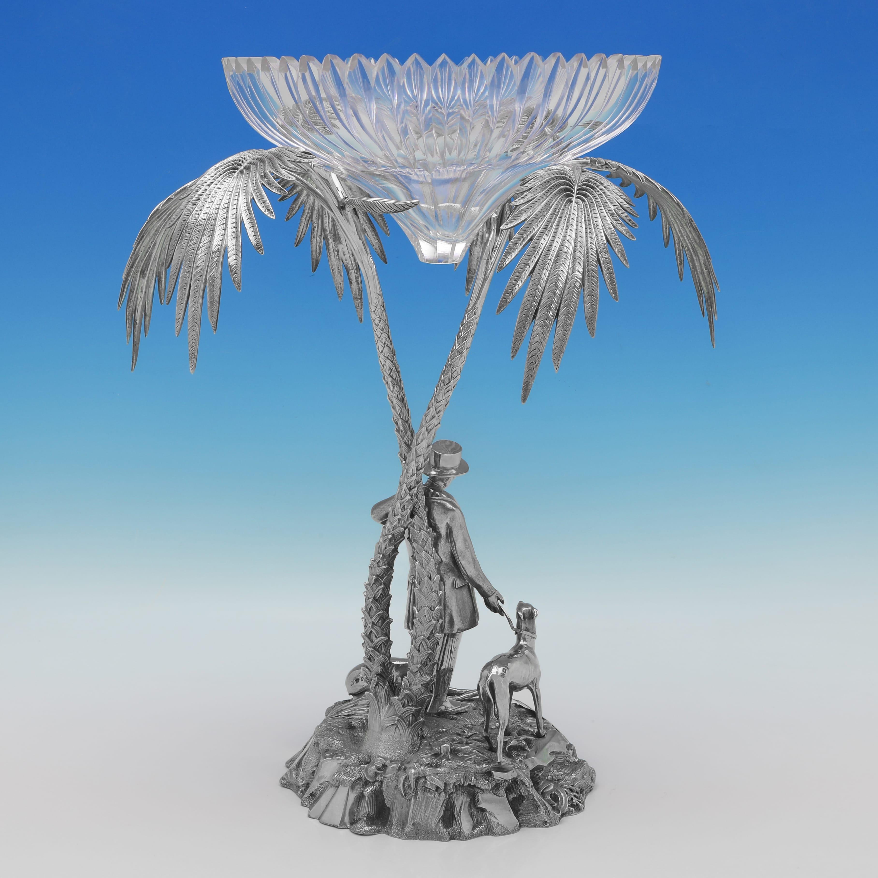 Poinçonné à Sheffield en 1873 par Thomas Bradbury & Sons, cet élégant centre de table victorien en argent sterling ancien représente un gentleman tenant un lévrier et se tenant sous un palmier. Le centre de table mesure 46 cm de haut, 33 cm de large
