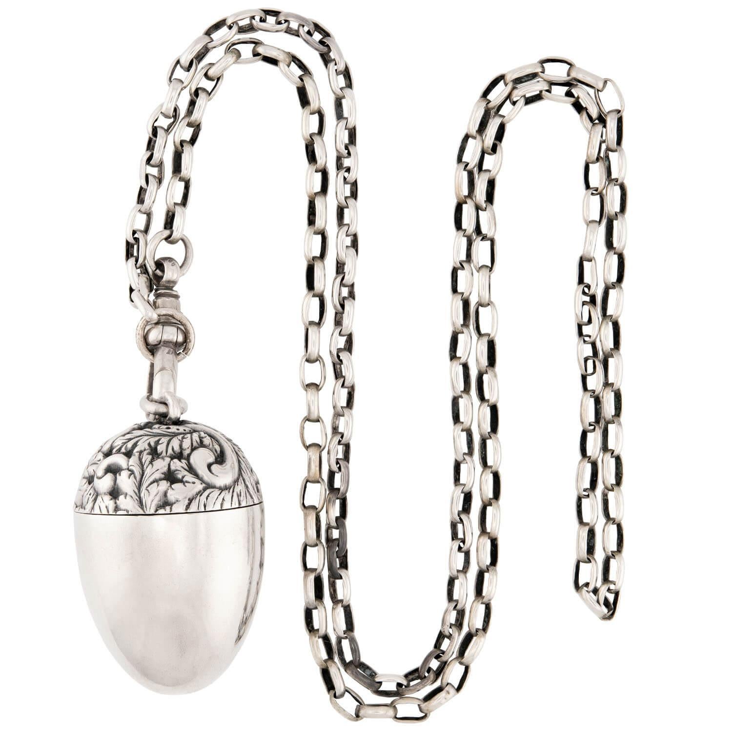 An unusual pendant necklace from the Victorian (ca1880s) era! Crafted in sterling silver, this piece features a large central acorn pendant, which is decorated with a wonderful foliate repoussé pattern. A lovely patina adds depth to the design, and