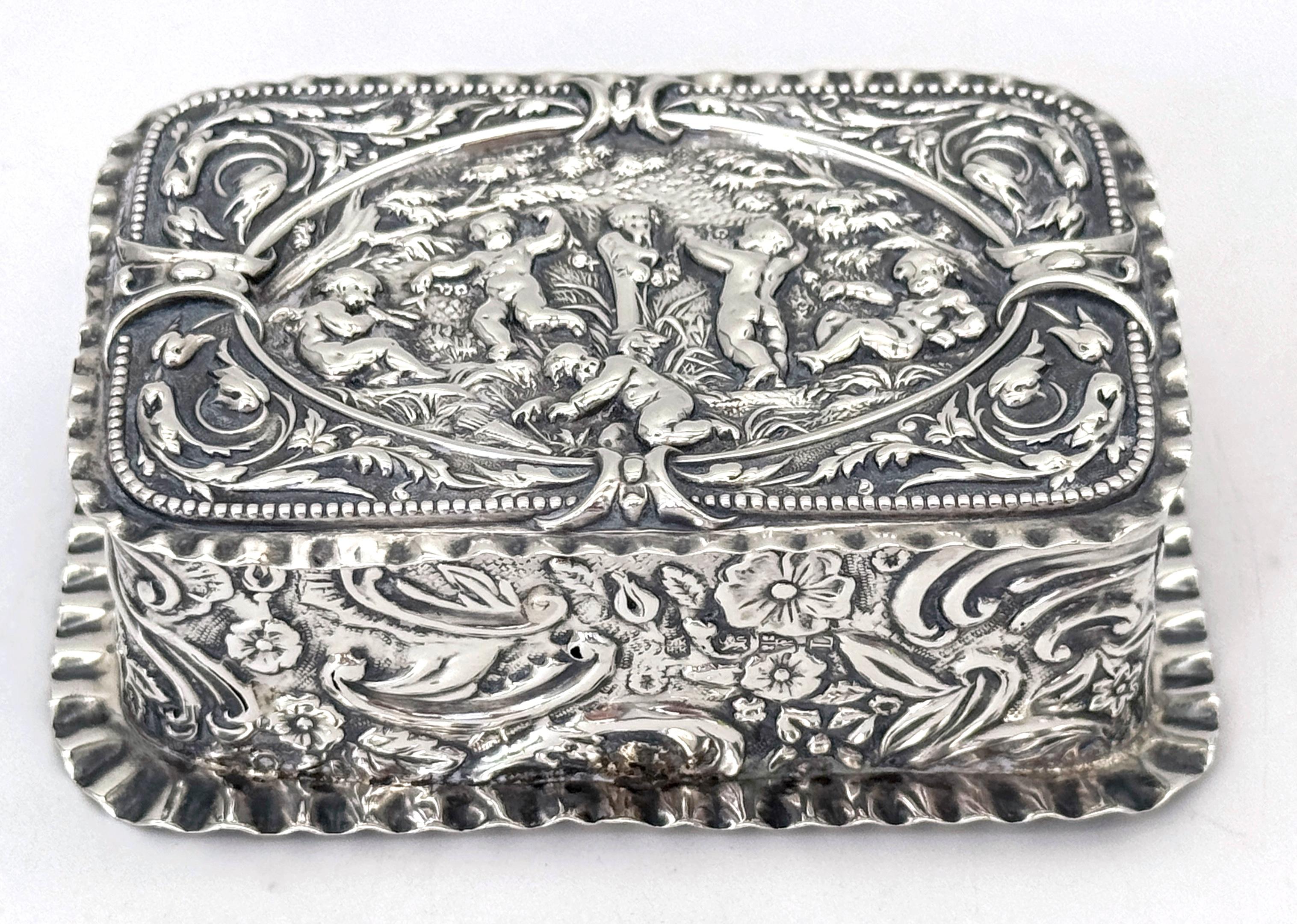 Caja Victoriana de Baratijas de Plata de Ley Repoussé con Escena de Jardín de Putti, Londres, 1886, por Jacob & John Keyser

Dimensiones: 3,75