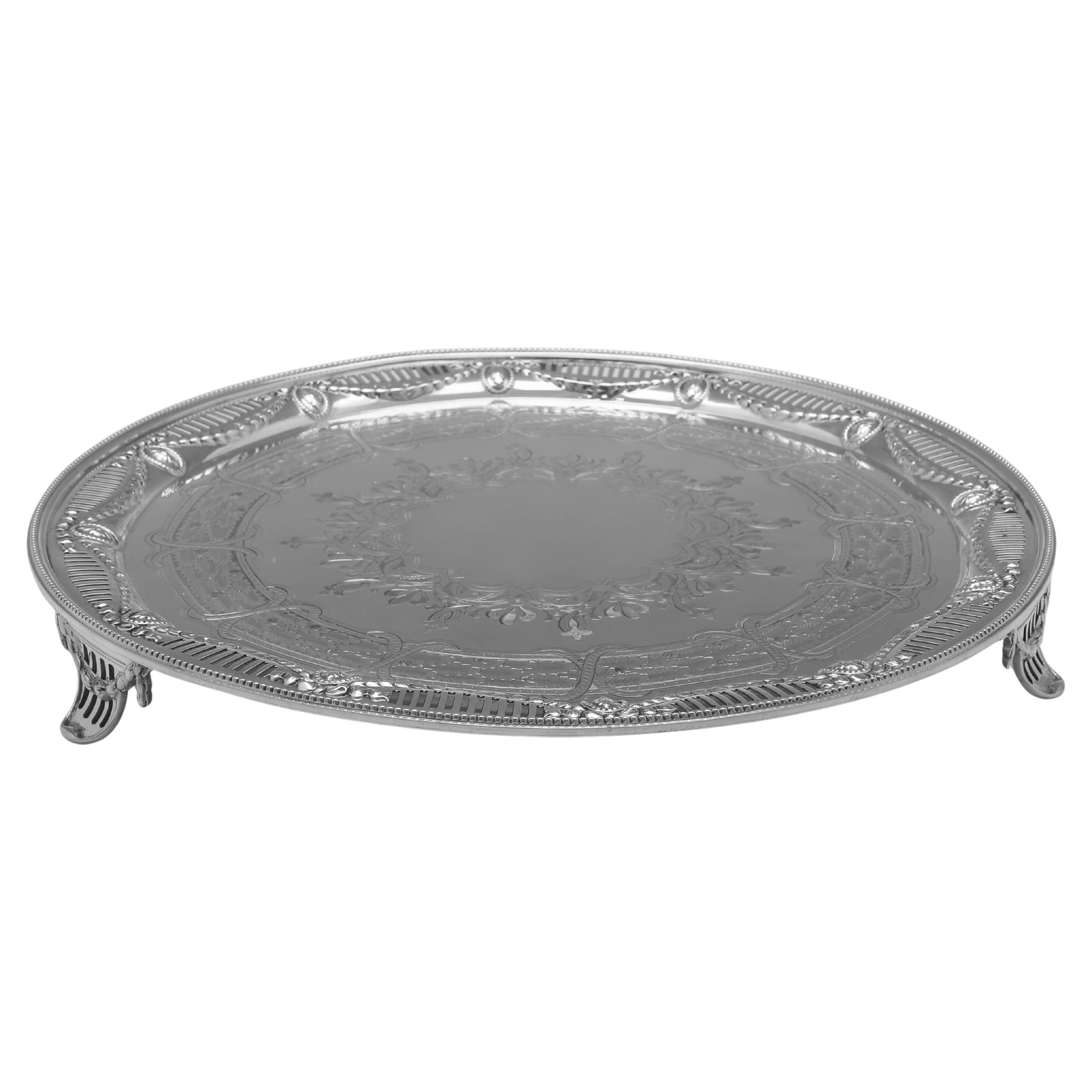 Marcada en Londres en 1868 por Martin & Hall, esta atractiva bandeja victoriana antigua de plata de ley tiene un borde perforado, 3 pies y una maravillosa decoración grabada en el centro. La bandeja mide 4,5 cm de alto por 37 cm de diámetro y pesa