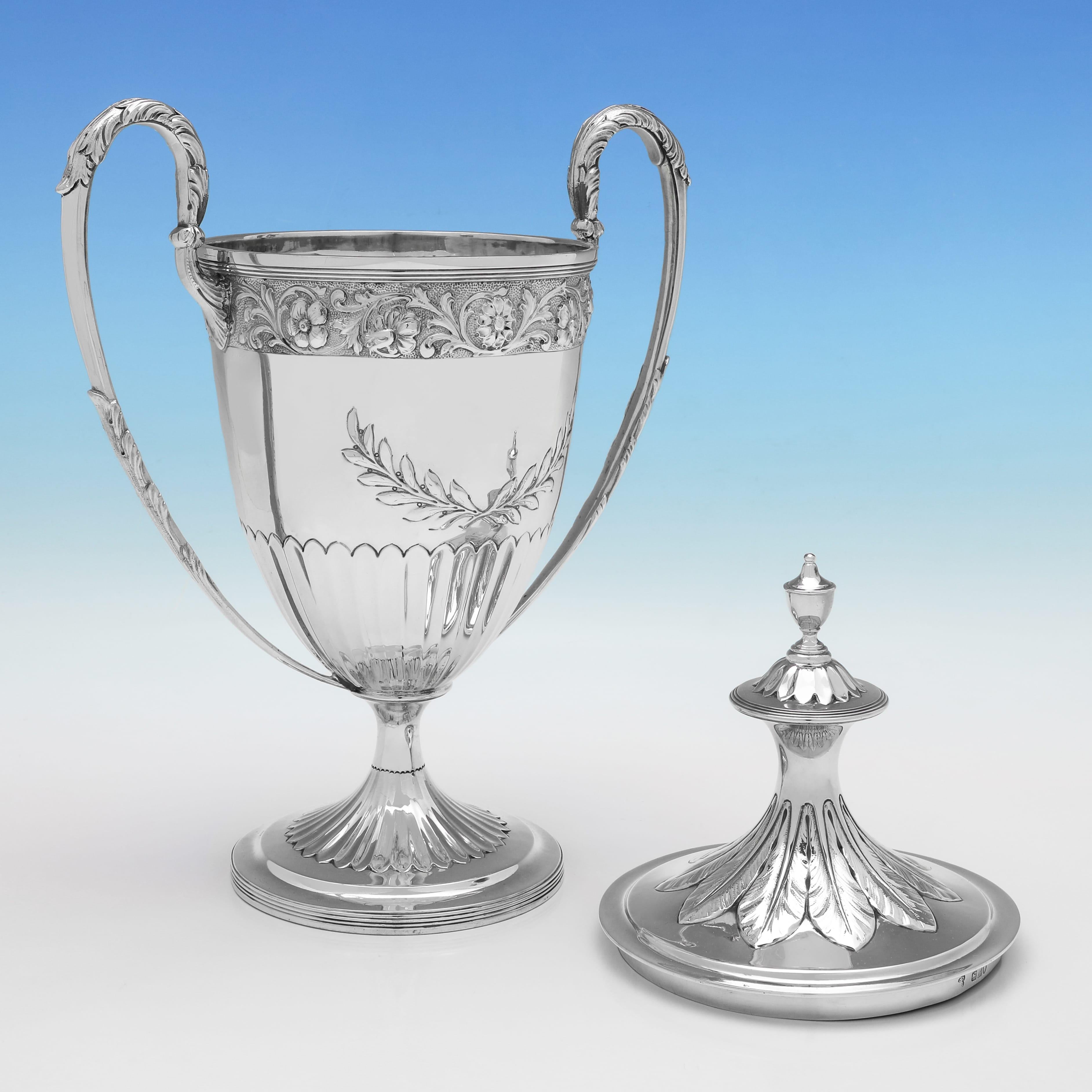 Marchiato a Londra nel 1898 da Charles Stuart Harris, questo elegante trofeo antico in argento vittoriano presenta decorazioni in stile neoclassico, scanalature incassate e manici ad anello con dettagli in acanto. Il trofeo misura 15