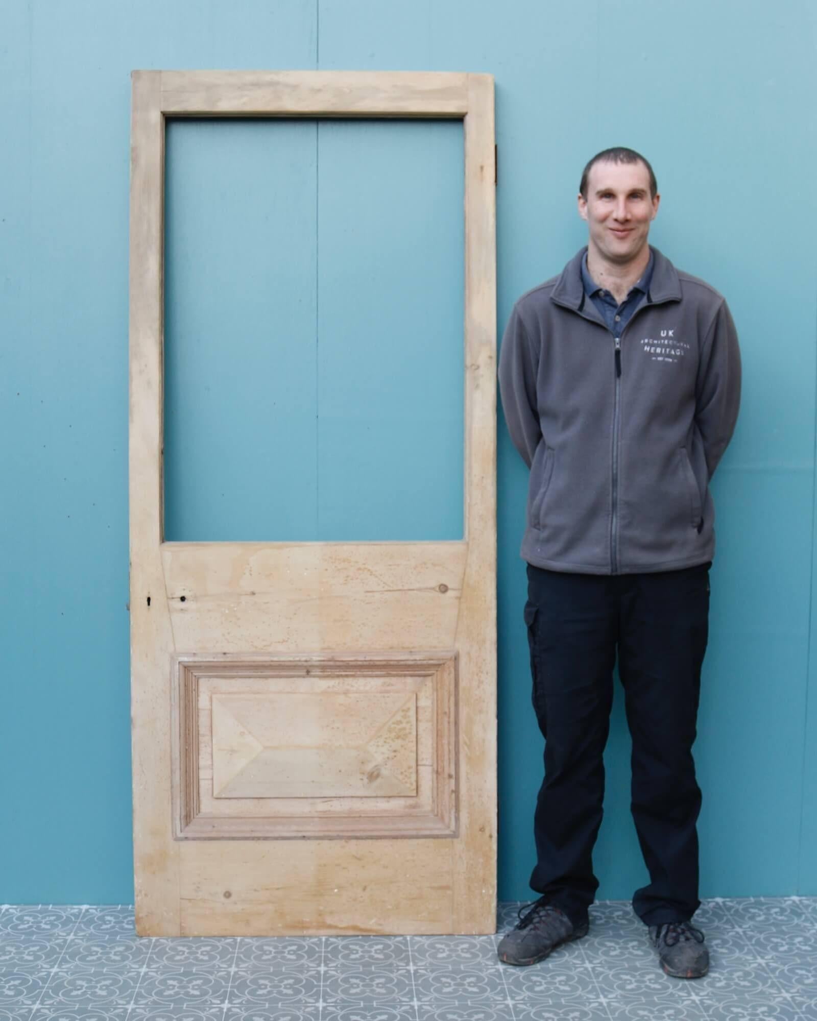 An unglazed reclaimed Victorian stripped pine door suitable for use as a front door or internal door. Constructed in pine, this antique door features a large panel for custom glazing above a raised pyramid panel to the front and flush panel reverse.