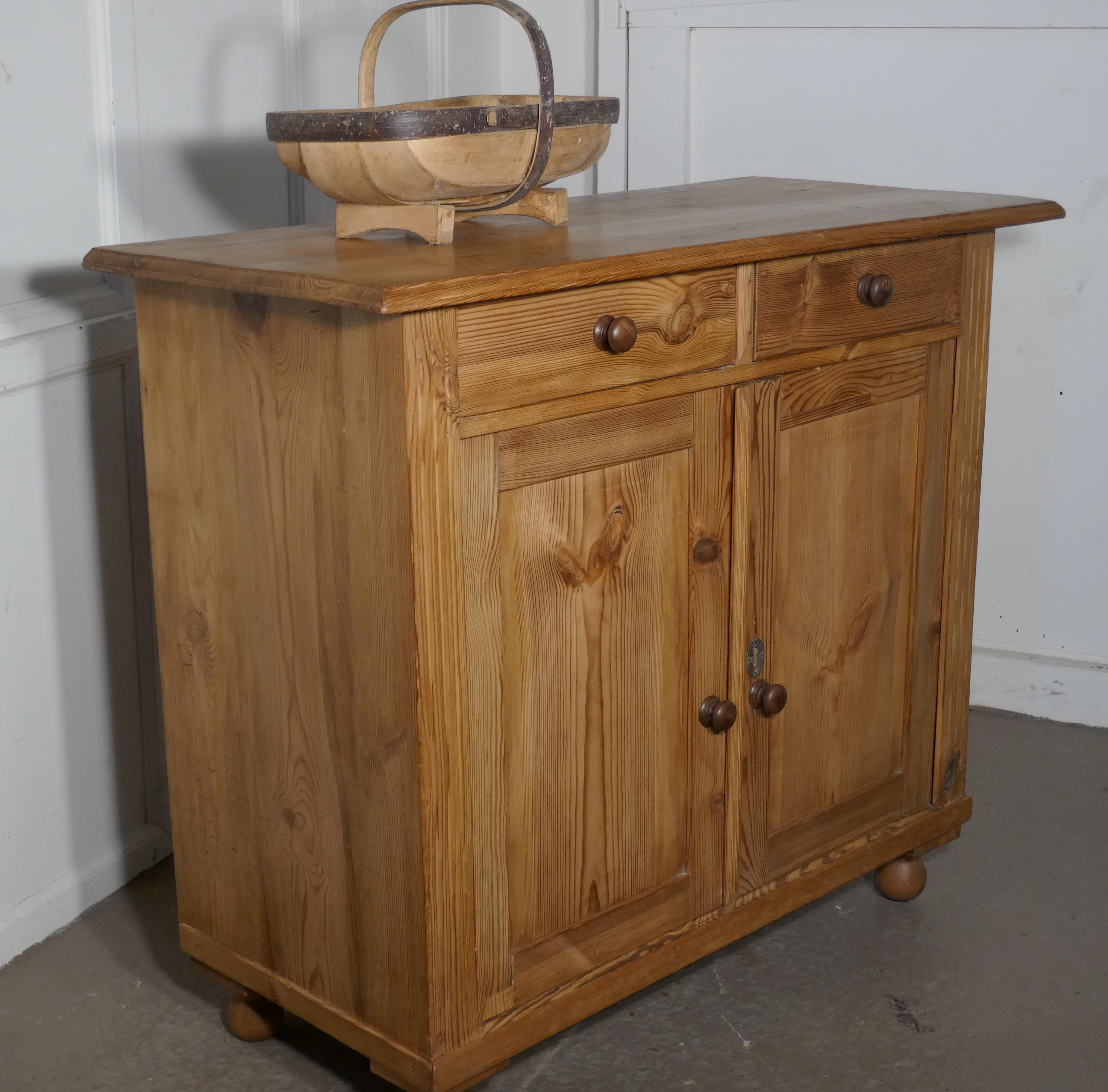 Victorian stripped pine sideboard or cupboard 

This is a very attractive farmhouse Kitchen cupboard, it has 2 drawers and 2 paneled doors enclosing a long shelved cupboard, with turned wooden knobs
The counter top has a molded edge and reeded