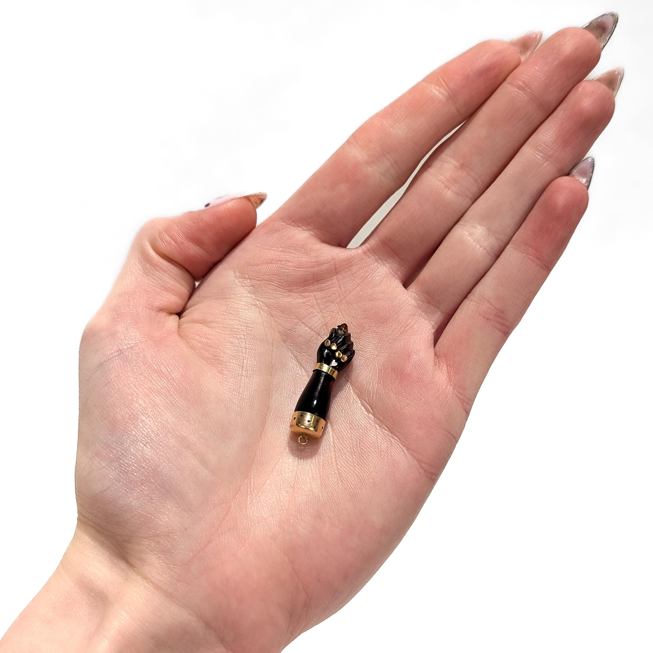 A fine gold mounted Figa hand pendant or charm.

In carved resin or shell.

With 18k yellow gold mounts.

In the form of the figa sign (a hand gesture that has been used for thousands of years across cultures). 

One of the predominant meanings is