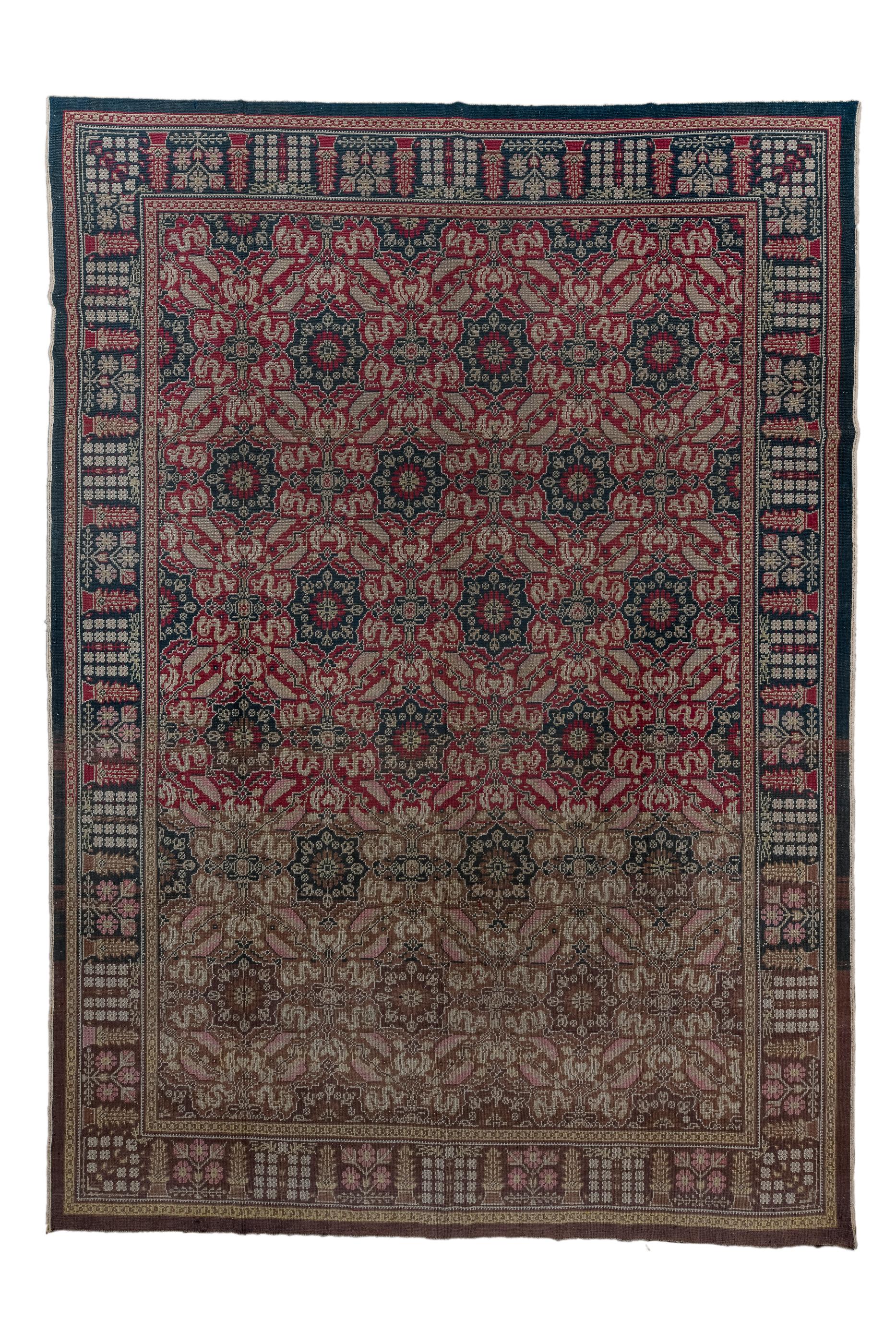 The darker red field shows an allover pattern of closely set small octogrammes,  leaves and wriggling cloudbands, in an Indian Esque pattern. Main dark brown border with square floret assemblages, flowering plants, and vases. Possibly English and