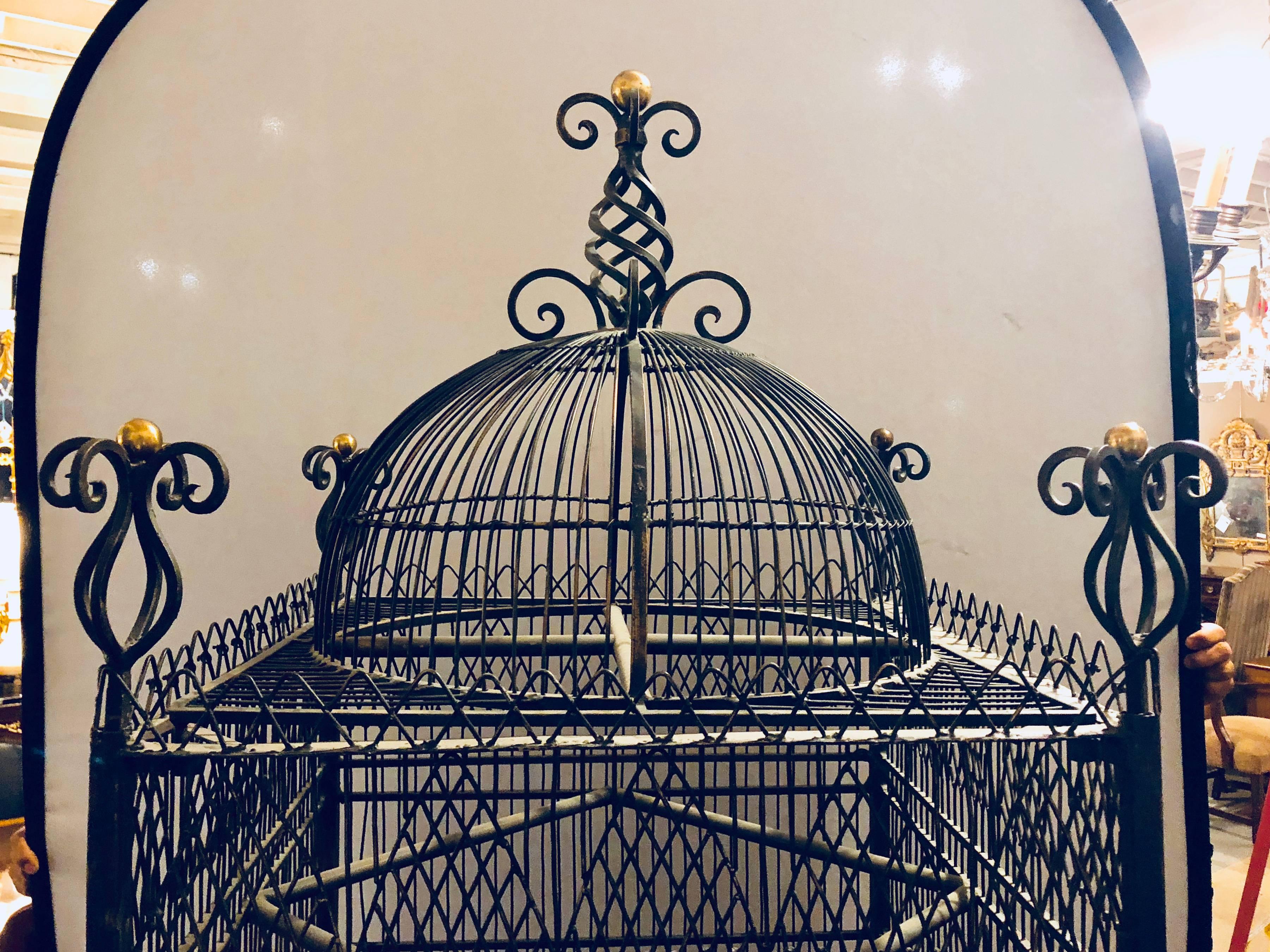 Victorian style turn of the century antique solid brass ebony painted monumental bird cage. Having a stand that is 33 inches in height this palatial birdcage is constructed of solid brass with an ebony finish and is certain to add conversation as