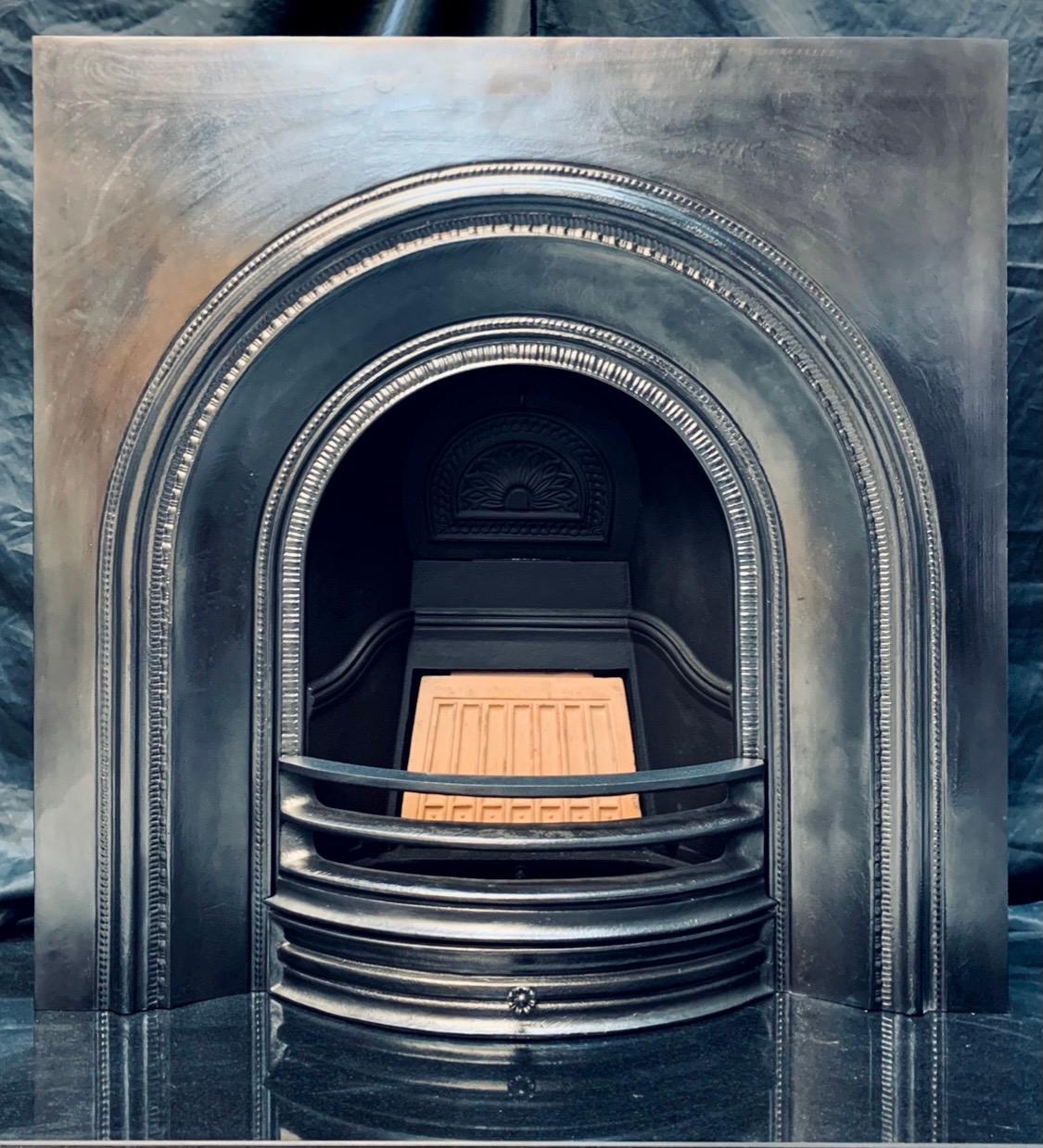 A simple and versatile arched cast iron fireplace insert in the Victorian manner. A raised arched border with fully working damper and fire brick, a three barred curved fire front with ash pan door. This piece is suitable for sold fuel or gas. 
  