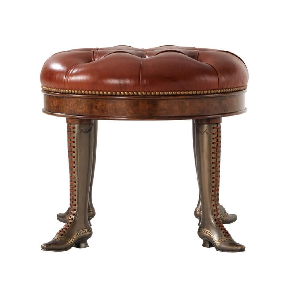 A Victorian style button tufted leather upholstered stool, with a circular seat, on antiqued brass can-can leather laced boot legs.

Dimensions: 29