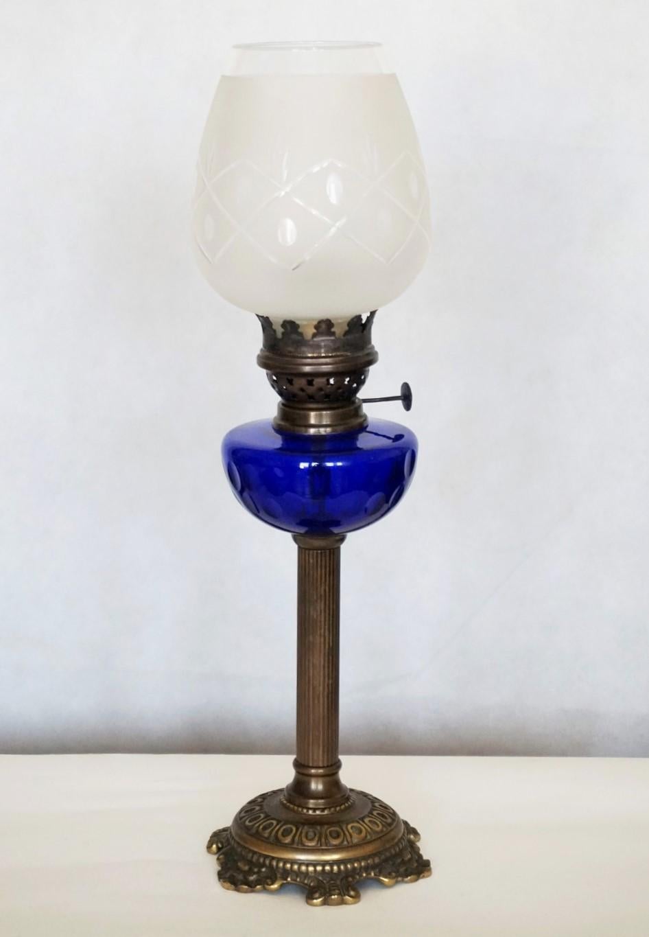 A lovely Victorian style cobalt blue cut glass font oil lamp raised on a patinated bronze fluted column and base, with cut glass shade,  This beautiful table lamp has been converted to electric with a brass and porcelain E-27 light socket for a