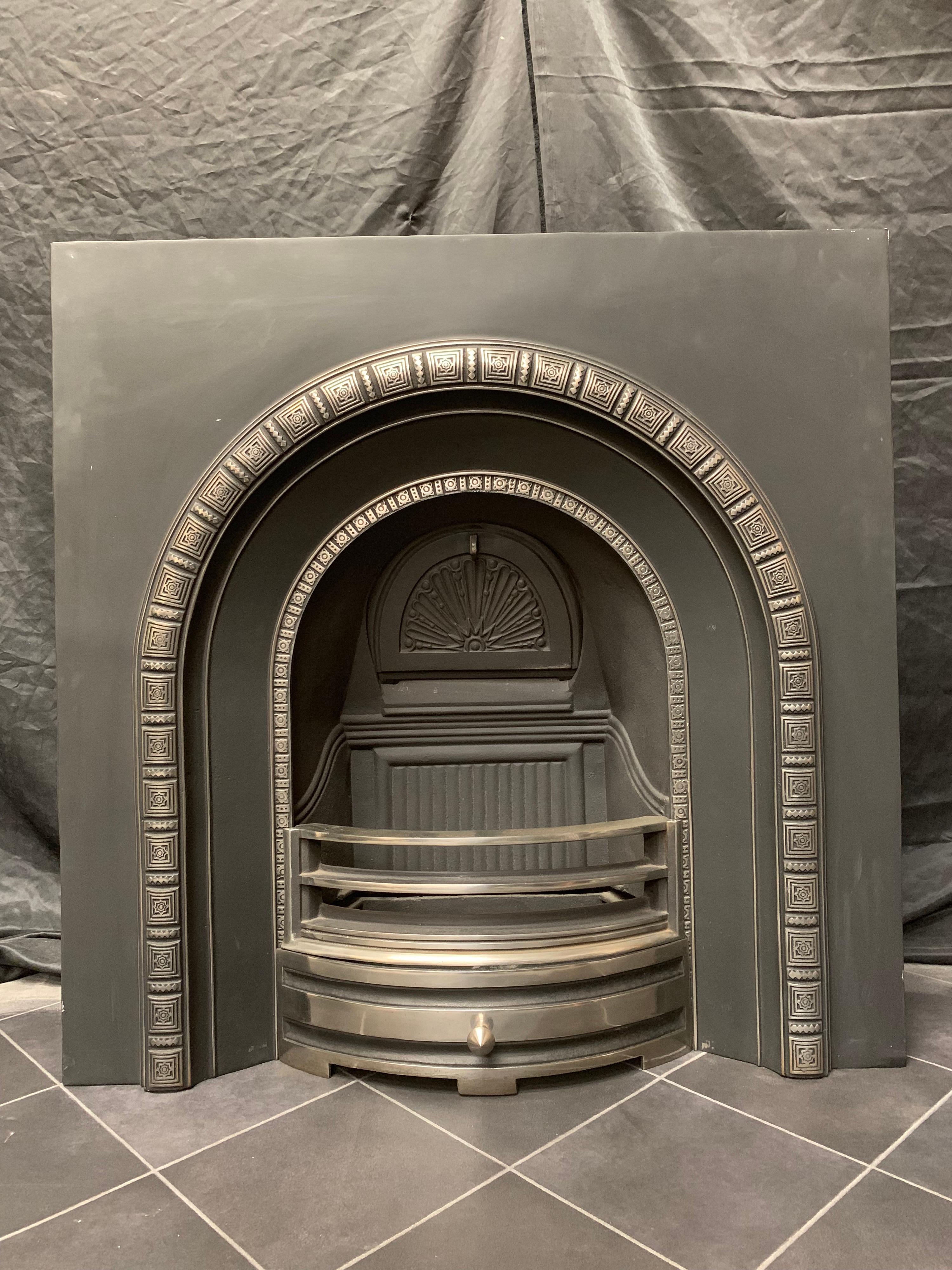 A Victorian style cast iron arched insert with highlighted rims and polished ash pan door and fire bars, comes with its original damper.

English, circa 1950.