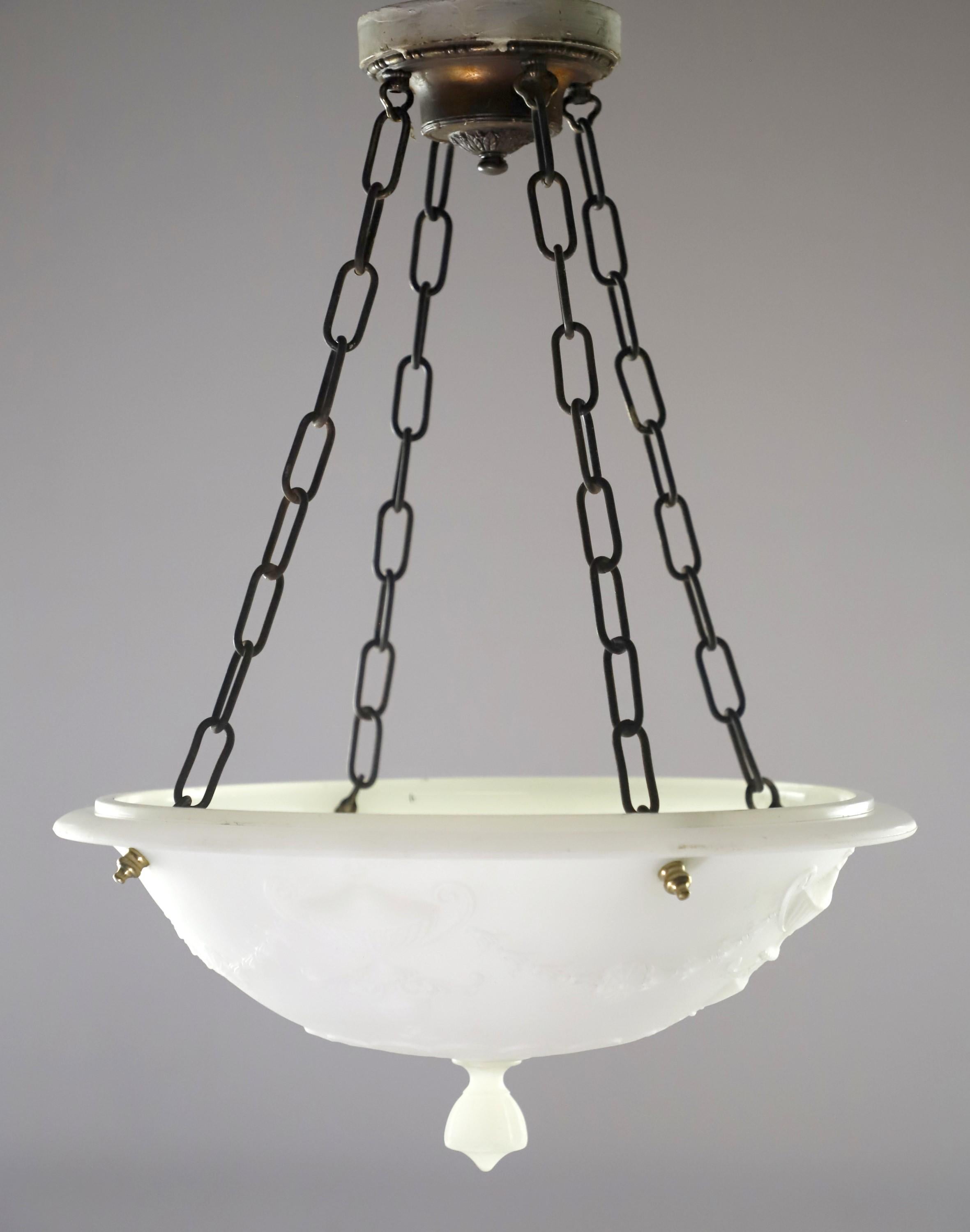 White cast milk glass dish pendant light with a floral, urn, and foliate motifs suspended from four chains with a bronze plated canopy. This will be cleaned and restored upon purchase. Takes four medium base light bulbs. Please note, this item is
