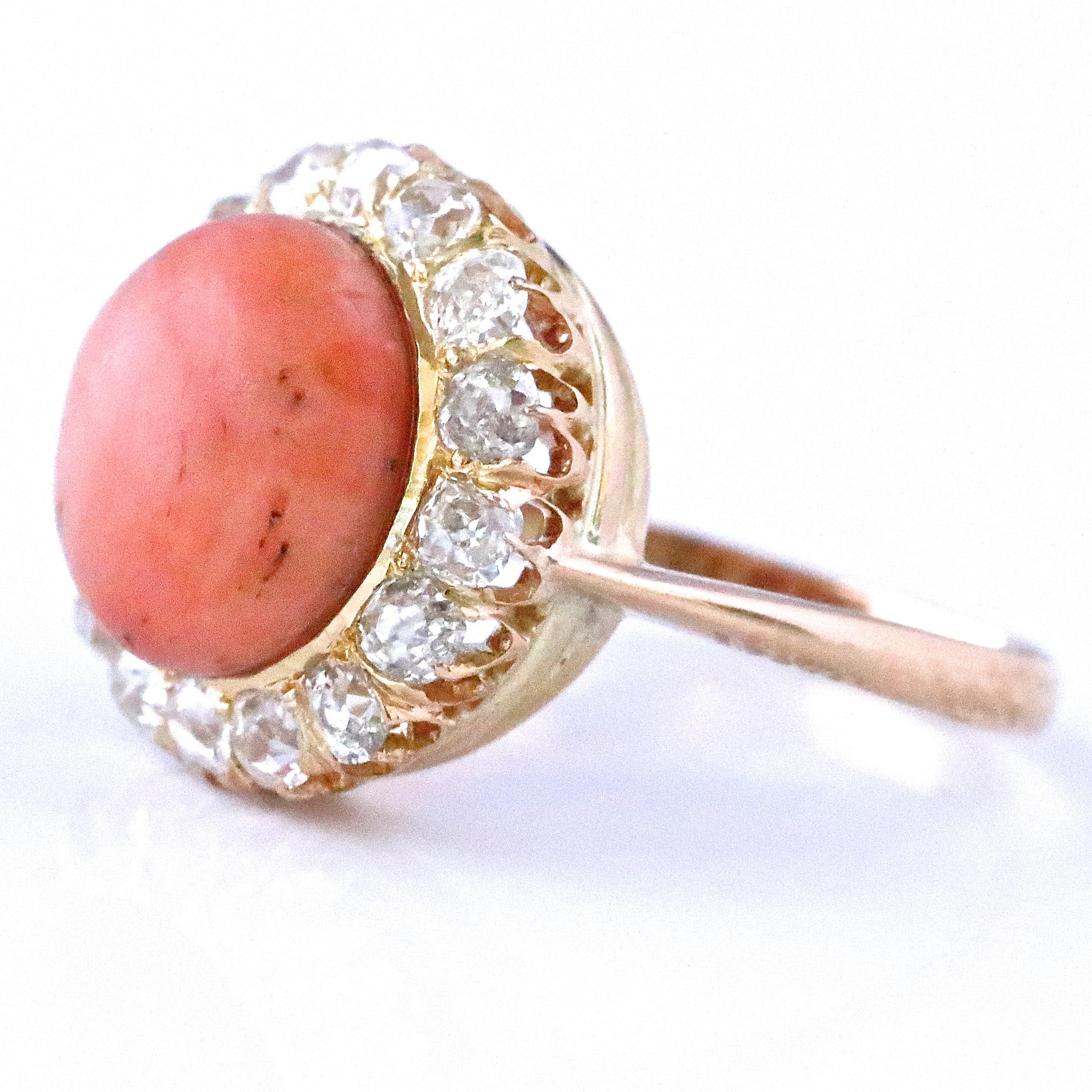 The Victorian period was a time of royalty, lavish lifestyle and beauty and this Victorian Style Coral Diamond Cluster Ring reflects it all. The center stone is a cabochon cut coral approximately 6.00 carats. Accented by 16 old mine cut diamonds