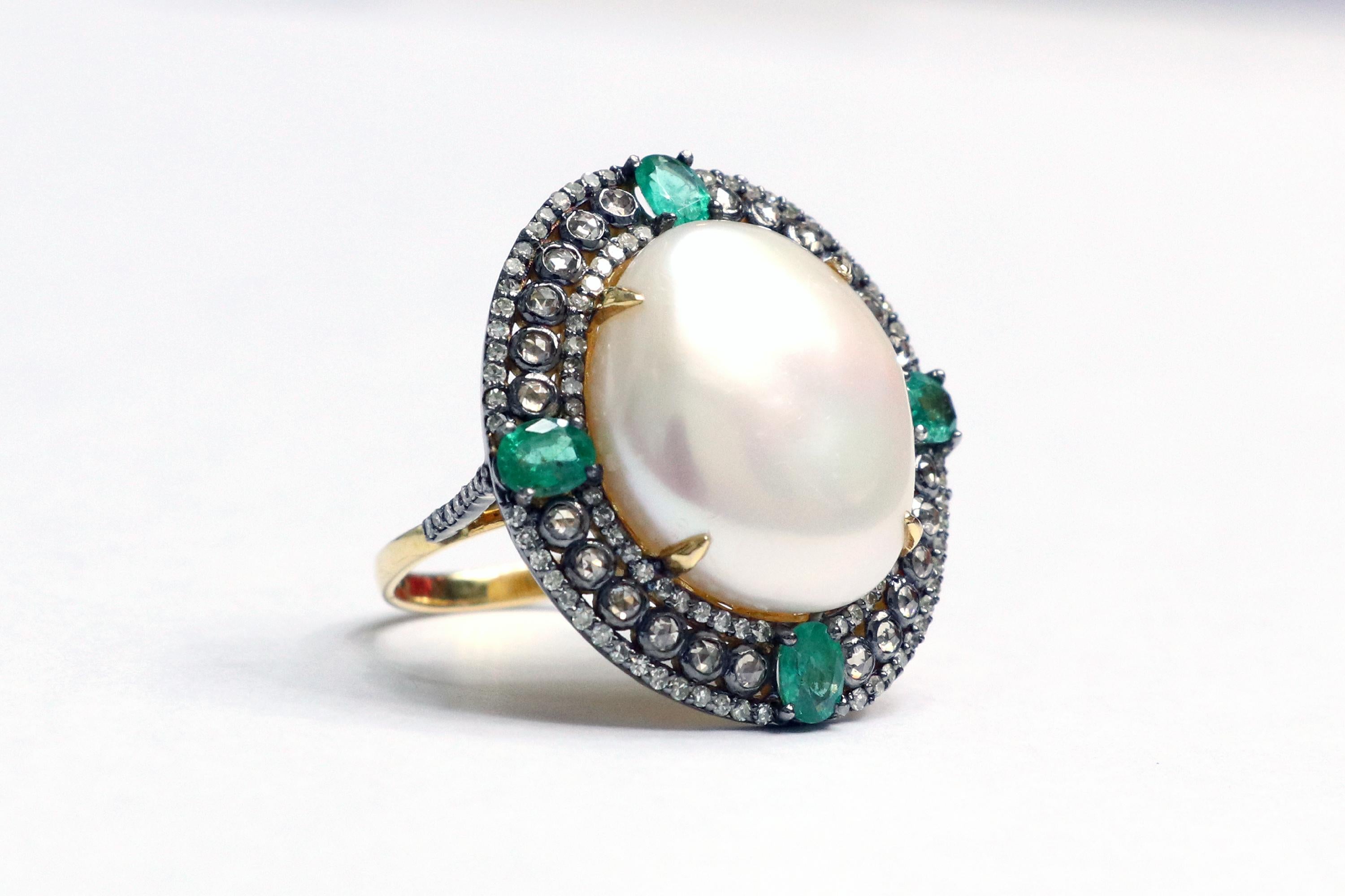 Victorian Style Emerald, Diamond, and Pearl Statement Ring

This distinctive sheen pearl, shamrock emerald diamond ring is glorious. The solitaire uneven cabochon shape natural half-dome pearl in yellow gold eagle prong setting is surrounded with