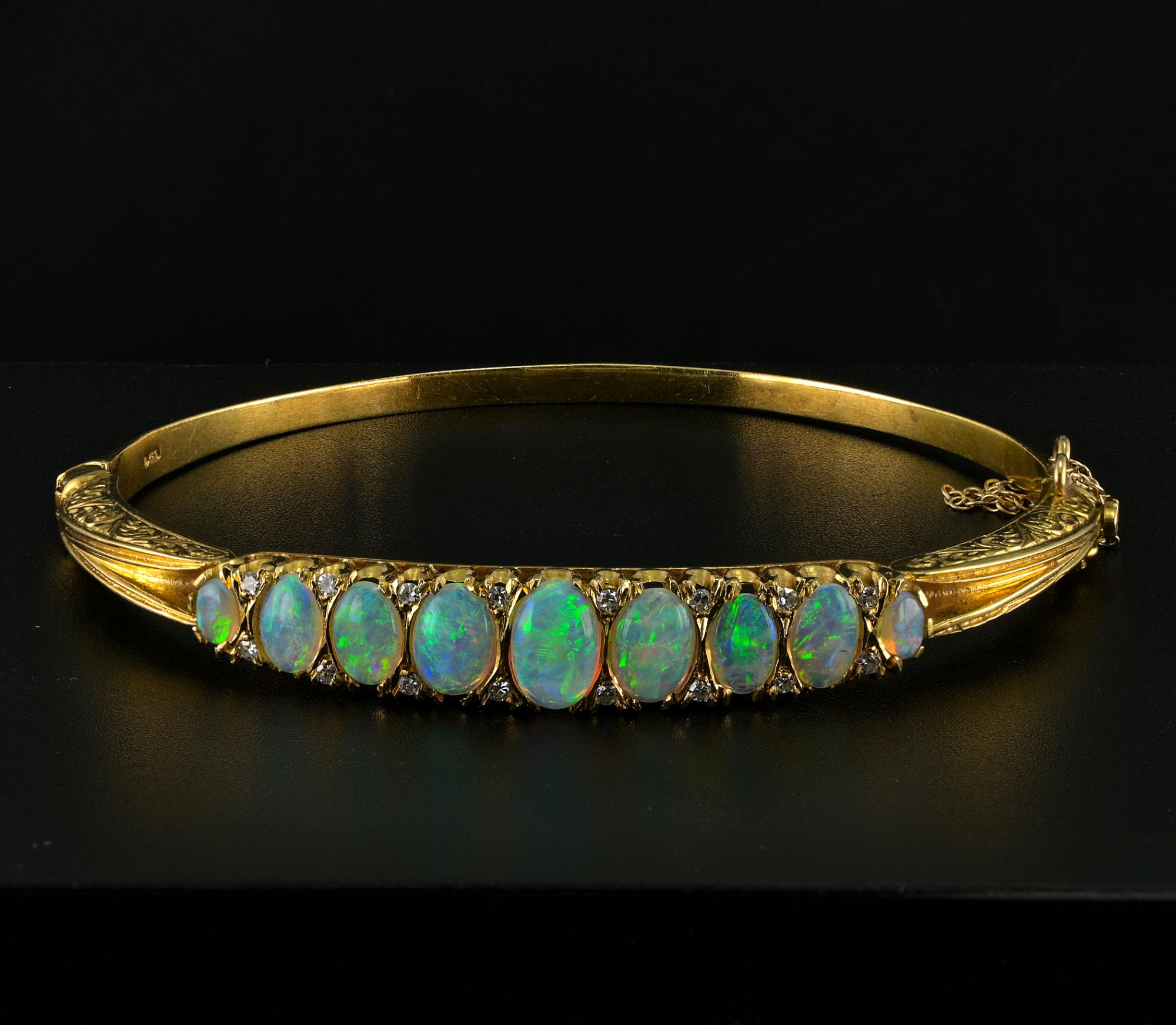 This outstanding English Victorian Style bangle is a vintage dated 1988 London – bearing full english hallmarks 18 KT
Stunning carving scroll work embracing the center graduated array of 9 natural Australian Opals with all spectrum of rainbow vivid
