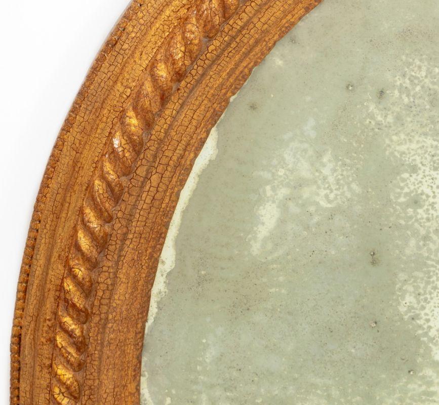 Miroir ovale biseauté en bois doré de style victorien. 40
