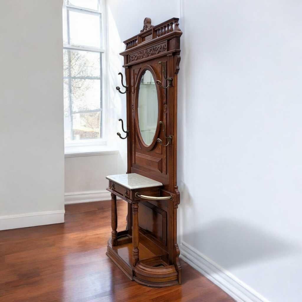 Un arbre d'entrée distinctif dans la tradition du renouveau victorien, fabriqué en bois massif et présentant des sculptures ornementales, une surface en faux marbre et des accents en laiton poli. Ce meuble d'entrée allie le charme de l'ancien à une