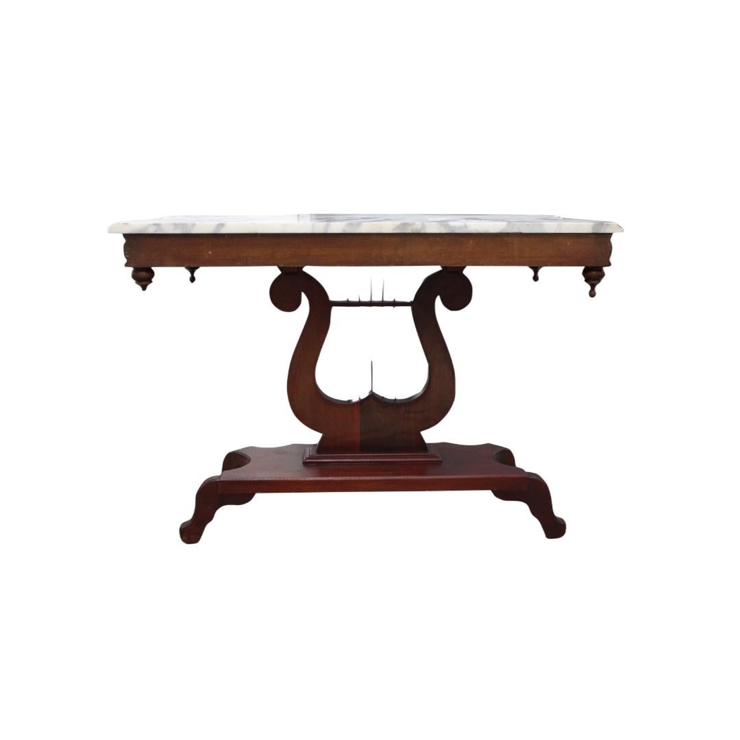 C. Early 20th century

Victorian style marble top mahogany table w/ harp design
* This end table / entry table does have a very small broken piece ( Circled in yellow ) *.