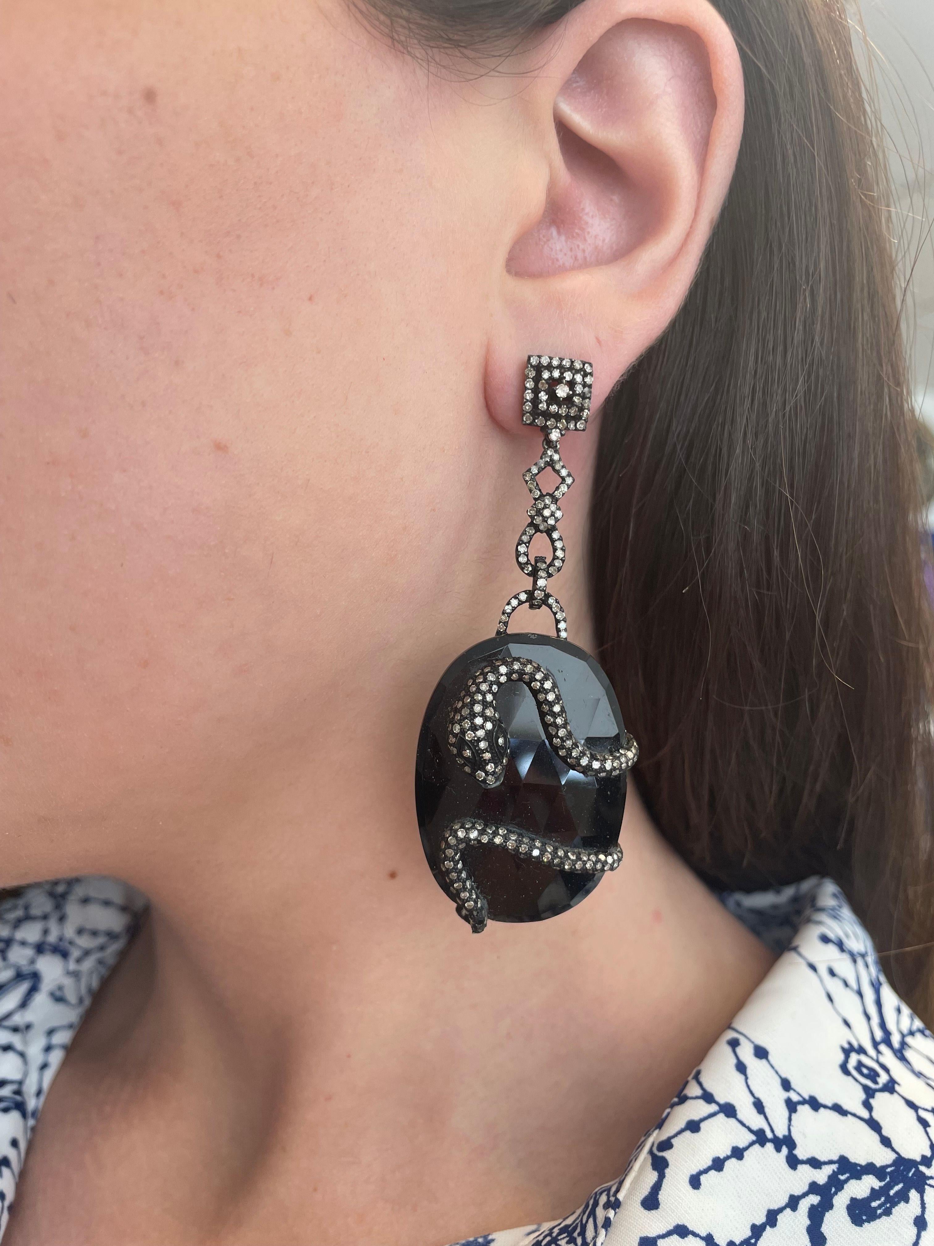 Statement Victorian inspired snake dangle earrings.
Approximately 2.40 carats of round cut diamonds, L/M color, and SI clarity on onyx. Silver and gold.
Accommodated with an up to date appraisal by a GIA G.G. upon request. Please contact us with any