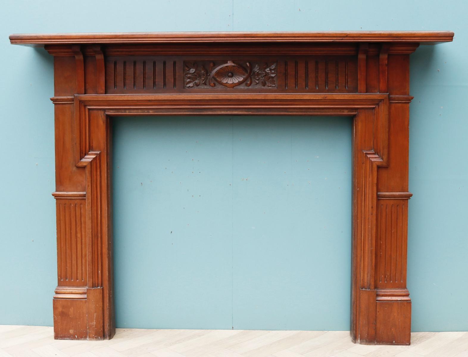 A walnut fire surround with carved frieze panel.

Additional dimensions 

Opening height 96.5 cm

Opening width 103.5 cm

Width between outsides of the foot blocks 153 cm.